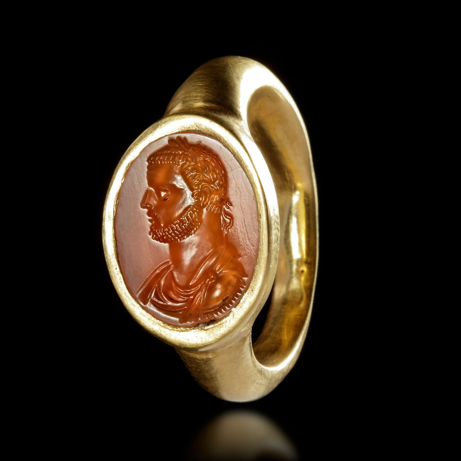A ROMAN GOLD RING WITH A CARNELIAN INTAGLIO SHOWING THE HEAD OF AN EMPEROR, 4TH CENTURY AD: A large Roman hollow gold ring with an orange carnelian intaglio showing a tetrarchic emperor (Diocletian). 25 by 29 mm. Size: 22 Weight: 7.2 gr.PROVENANCE From a European collection formed in the 198