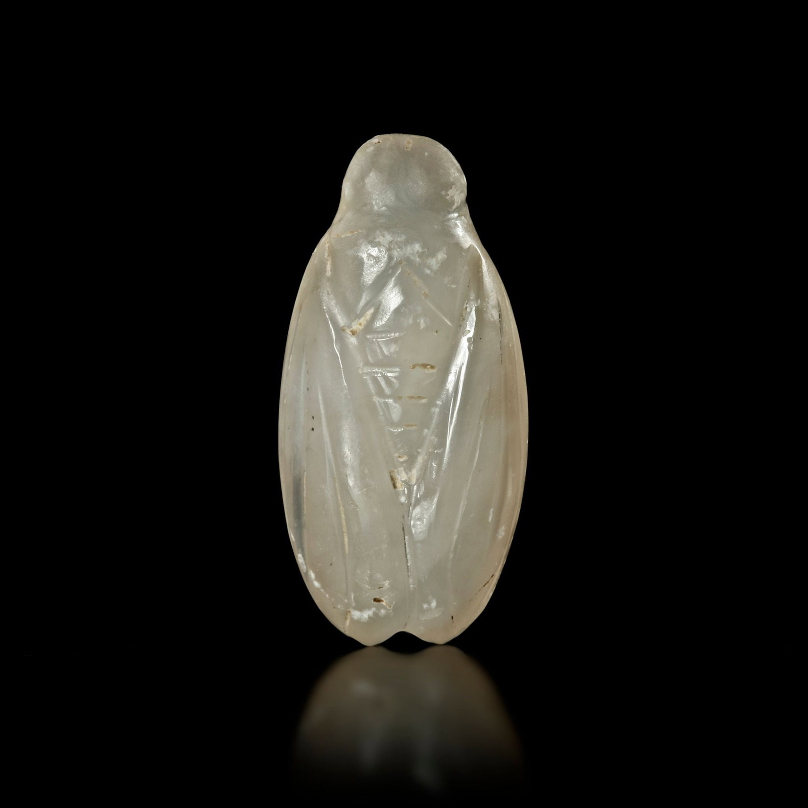 A ROMAN CHALCEDONY AMULET IN THE FORM OF A CICADA, 1ST CENTURY AD: A Roman amulet made of light grey chalcedony in the form of a cicada. Length: 31 mm. Weight: 6.7 gr. PROVENANCE Ex-European private collection acquired before 1970