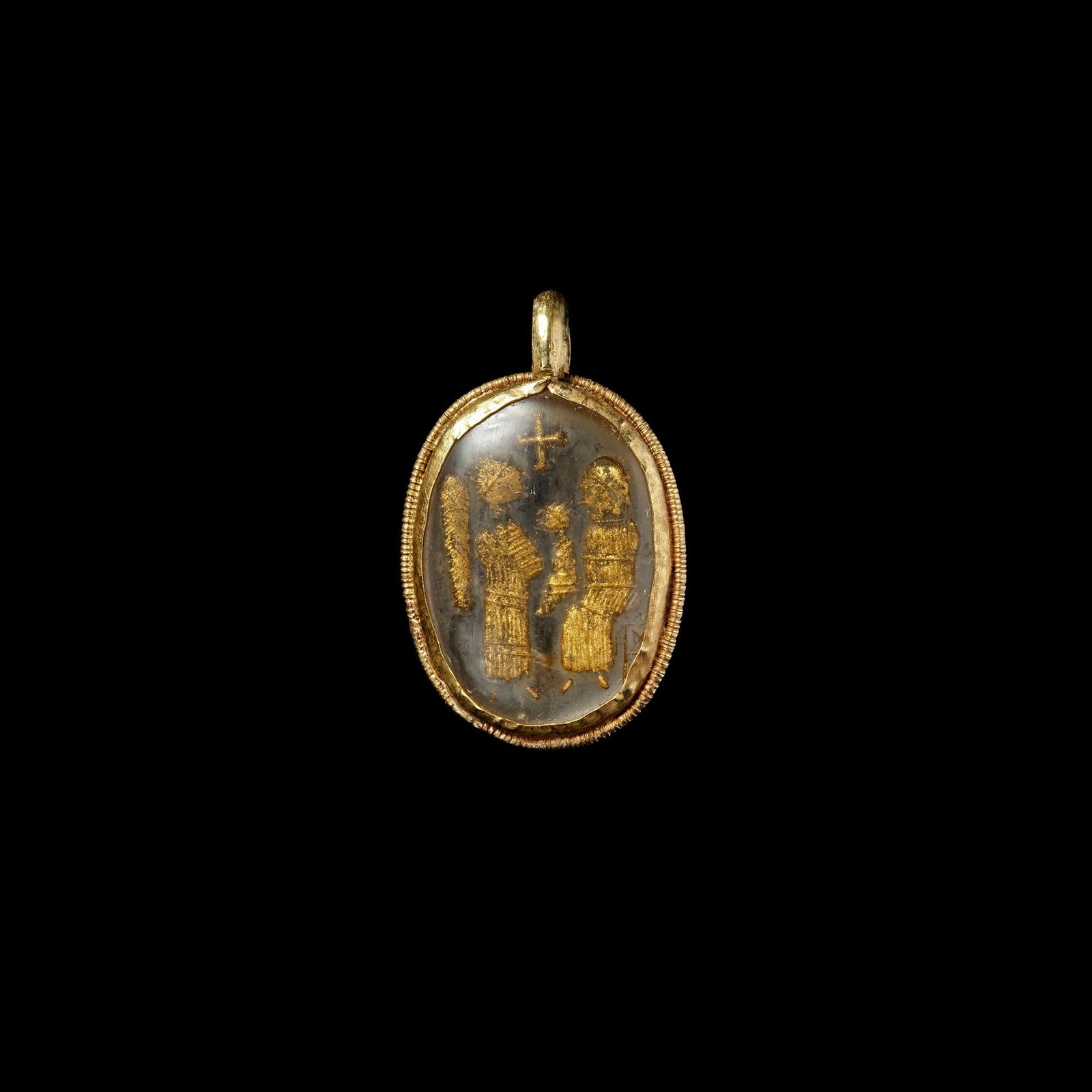 A GOLD AND ROCK CRYSTAL PENDANT BYZANTINE, 6TH CENTURY AD: A Byzantine pendant in gold and rock crystal. The technique involved two oval cabochon rock crystal element, one of which was engraved on the flat side and then gilded with gold dust and a substance f