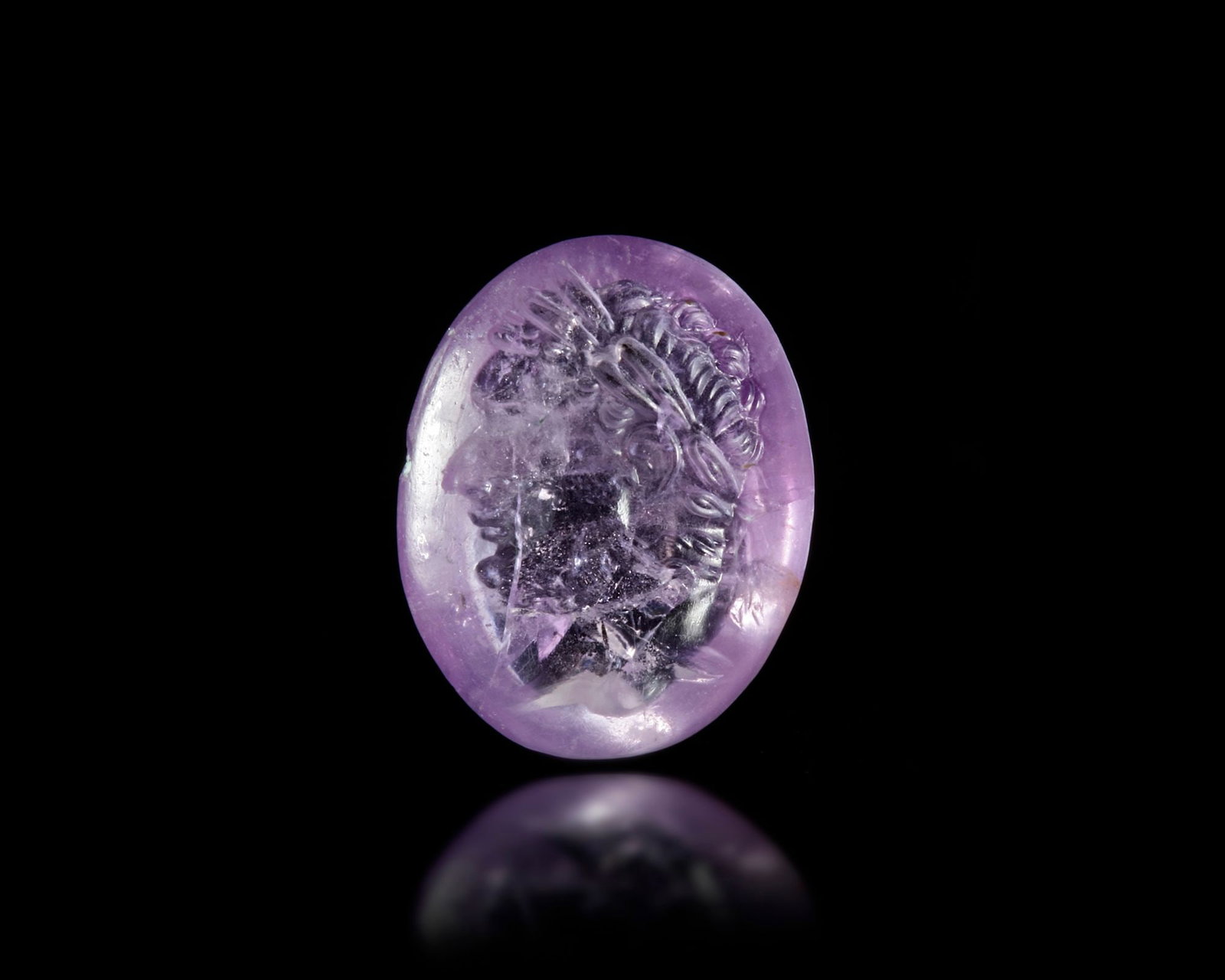 A HELLENISTIC AMETHYST INTAGLIO 2ND TO 1ST CENTURY: The nice colour intaglio is depicting the portrait of a Seleucid king probably Demetrius the second.Dimensions: 1.2 by 1. cm