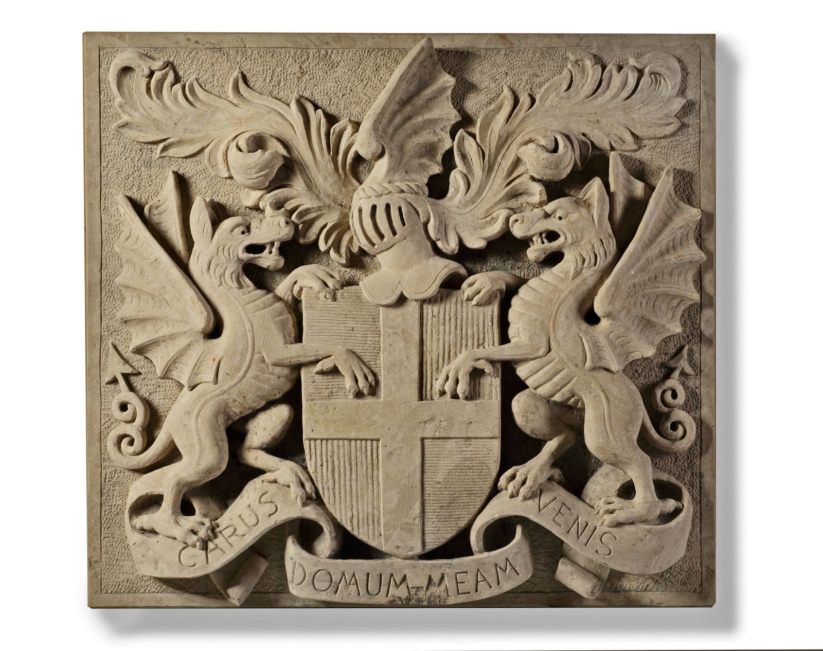 A SCULPTED LIMESTONE ARMORIAL PANEL, SECOND HALF 20TH CENTURY: Almost certainly Continental, of rectangular form, relief carved with a central shield with cross, beneath a helmet and rising foliage, flanked by heraldic bearers, above the motto â€?CARUS DOMU