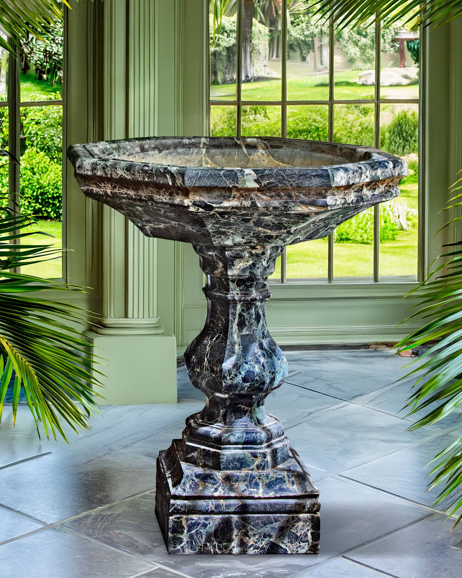 A CARVED VARIEGATED GREEN MARBLE BASIN OR CISTERN, LATE 19TH OR EARLY 20TH CENTURY: The octagonal basin above the baluster pedestal and spread base. Height 110 cm. Diameter 92 cm. Square at the base 42 cm.
