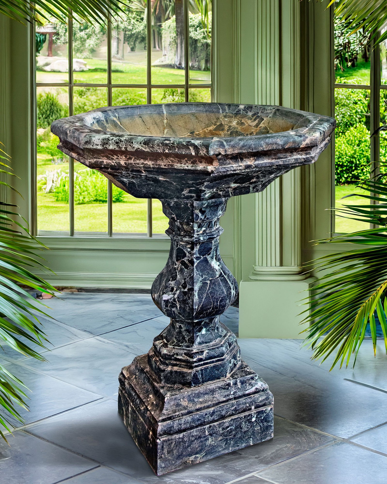 A CARVED VARIEGATED GREEN MARBLE BASIN OR CISTERN, LATE 19TH OR EARLY 20TH CENTURY: The octagonal basin above the baluster pedestal and spread base. Height 110 cm. Diameter 92 cm. Square at the base 42 cm.