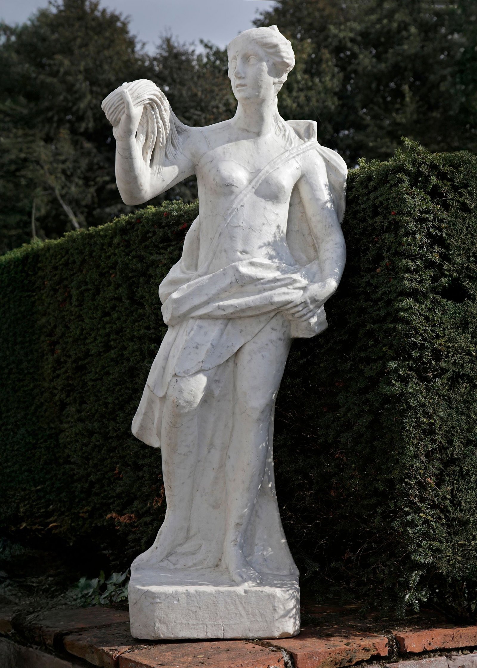A MARBLE STATUE OF A WOMAN, 17TH CENTURY: A white marble representation of a woman in a classical style. A marble statue of a woman with grain usually represents fertility, agriculture, abundance, and the life-giving power of nature. Height o