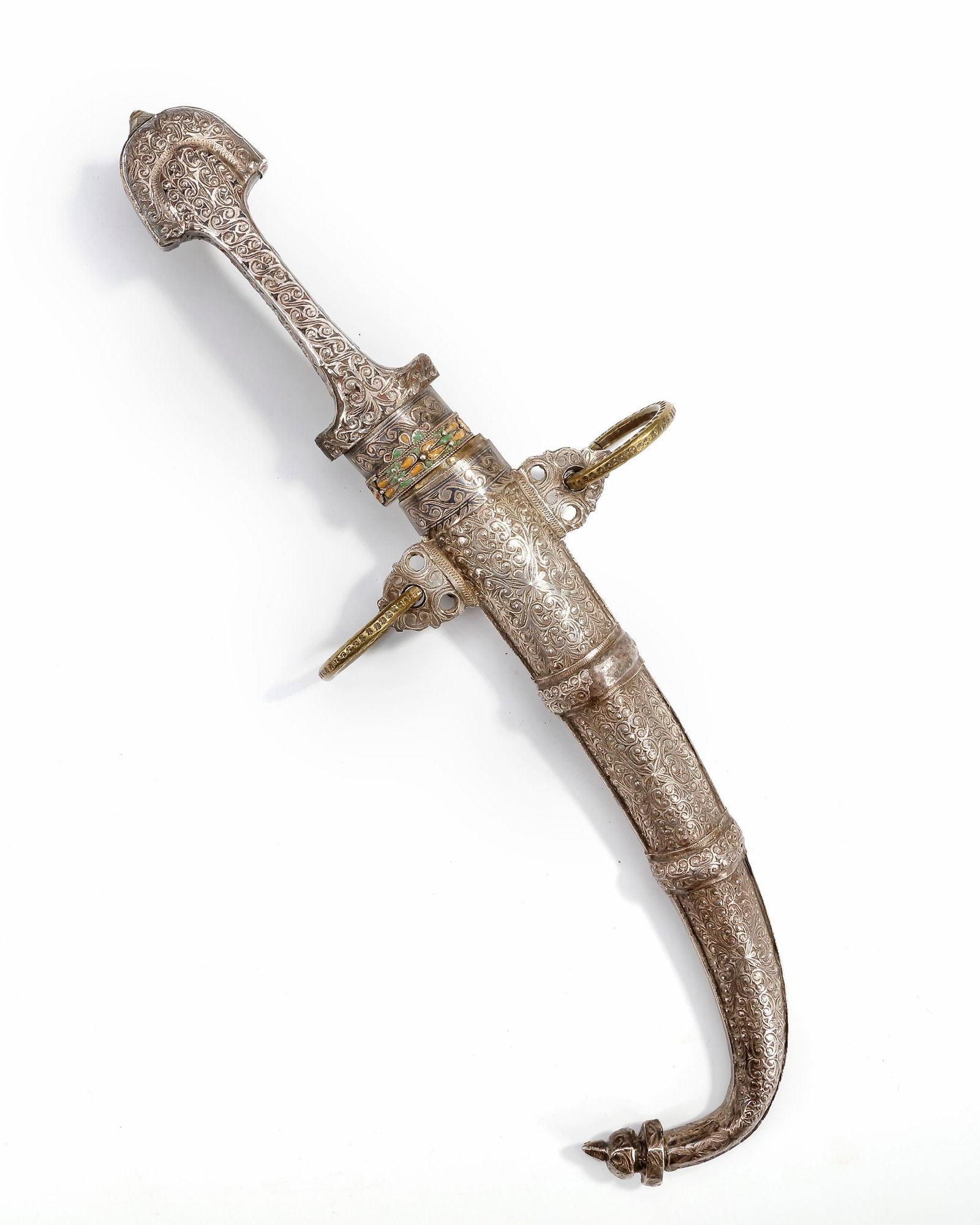 A SILVER DAGGER, MOROCCO, 19TH CENTURY: A finely crafted Moroccan dagger with a richly engraved silver hilt and sheath. The handle and scabbard are adorned with intricate scrolling floral motifs, highlighted with touches of enamel decoratio