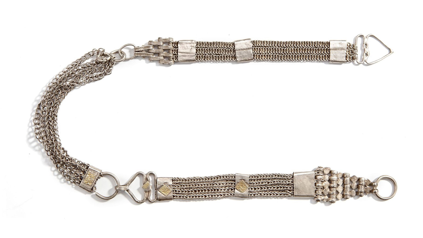 A SILVER BELT, OMAN, 19TH CENTURY: With multiple woven chain strands joined by engraved fittings. The central plaque is decorated with geometric designs and a gilded panel. ca. 68 cm. 177 gr. THE DR. SAAD AL-JADIR COLLECTION