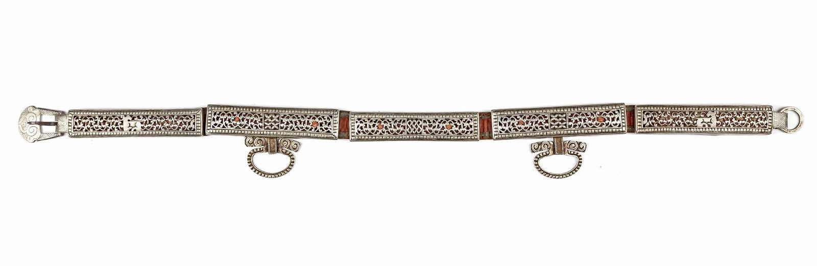 A CAUCASIAN SILVER BELT, 19TH CENTURY: Composed of rectangular panels decorated with intricate openwork arabesque designs and inlaid with red accents. The belt features ornate loops for suspension and a detailed clasp. 86 by 3 cm. THE DR. 