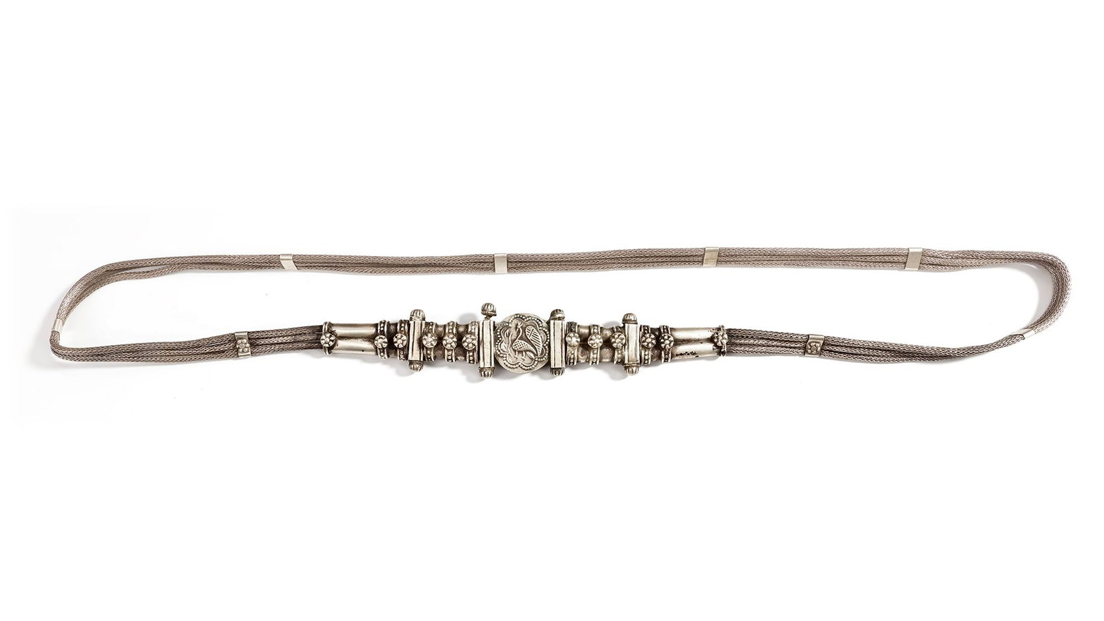 AN AFGHAN SILVER NECKLACE, 20TH CENTURY: Featuring multiple woven silver strands joined by a richly decorated central clasp with floral and bird motifs. ca. 82 cm. 120 gr. THE DR. SAAD AL-JADIR COLLECTION