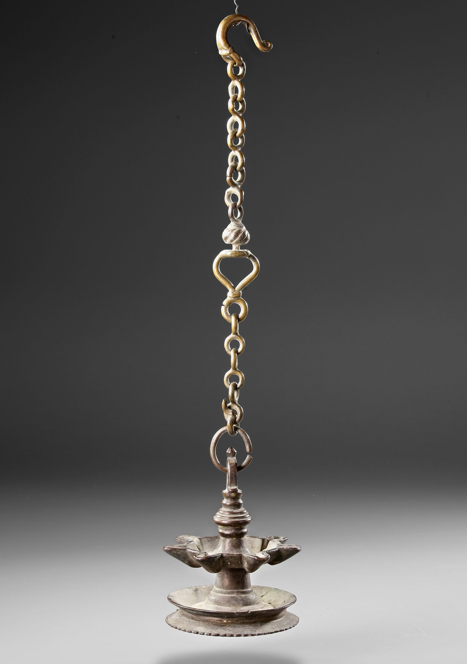 A PERSIAN-KHORASSAN BRONZE LAMP STAND 14TH -l5TH CENTURY: This finely cast bronze lamp stand originates from the Khorassan region of Persia, dating back to the 14th-15th century. Designed to hold oil lamps, it features a lotus-shaped reservoir supported by a