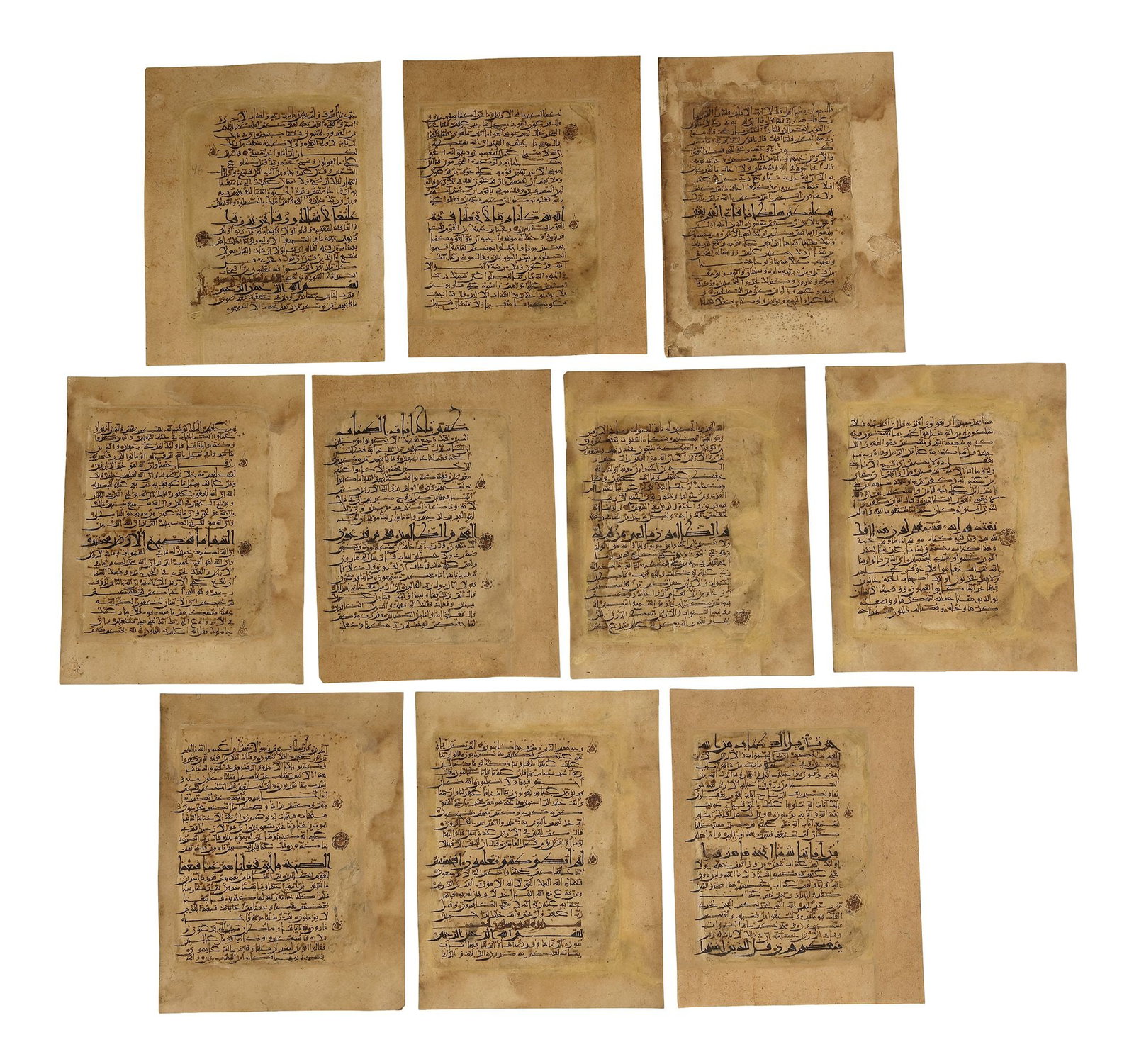 ELEVEN QURAN PAGES, PERSIA, 11TH CENTURY: Arabic manuscript on paper, each page comprising 20 lines, written in an elegant Eastern Kufic script in black ink. Diacritics and tajwÄ«d are rendered in brown ink, with rosette verse markers throu