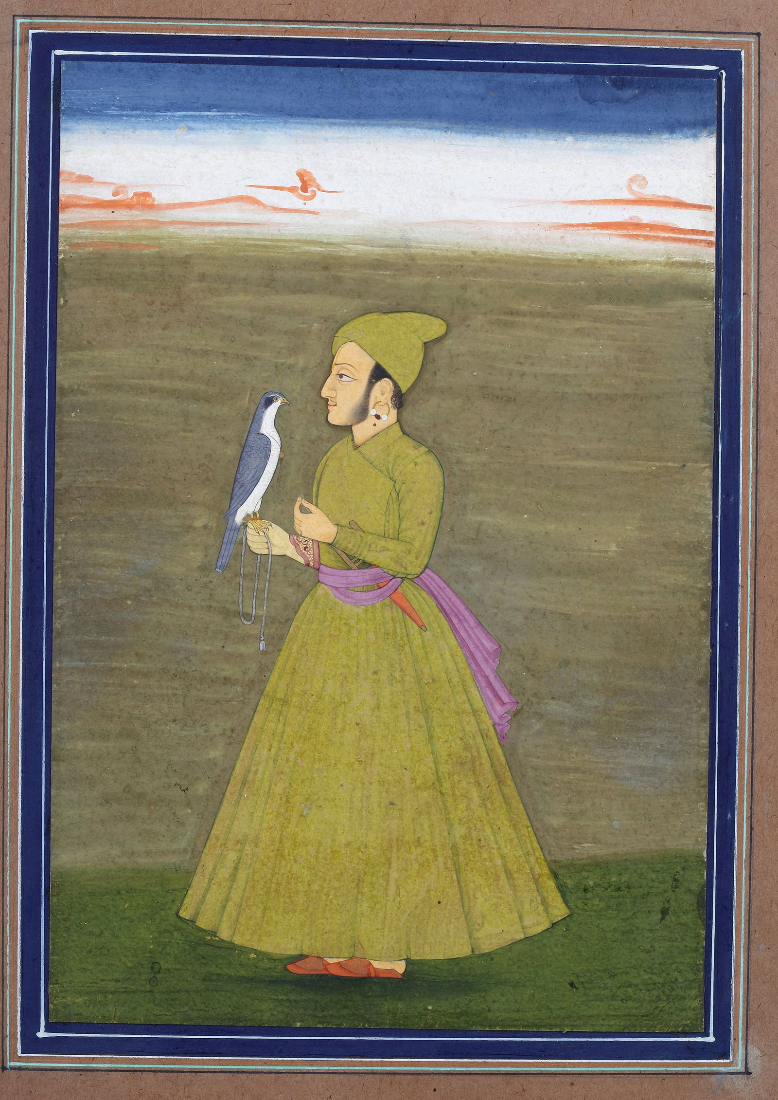 A FALCONER WITH HAWK, 19TH CENTURY: A 19th-century Indian miniature painting depicting a noble falconer standing in a landscape while holding a trained hawk on his gloved hand. Dressed in an elegant robe and turban, the figure reflects 