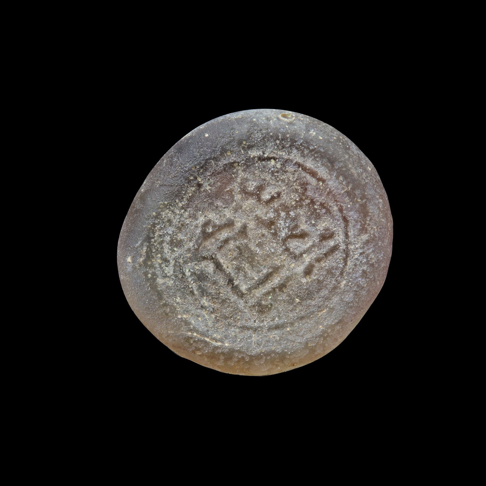 AN EARLY ISLAMIC GLASS WEIGHT OF DIRHAM: Glass weight, moulded and stamped, transparent white in colour, citing in the centre with the name Al-Aziz Billah (364-386 AH/975-996 AD). 2.859g, 19 mm. coin weight: dirham.
