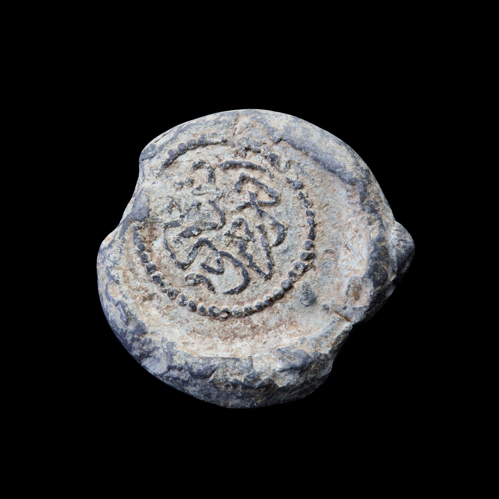 AN EARLY ISLAMIC VESSEL STAMP, 14TH-15TH CENTURY: A metal vessel stamp, moulded and stamped, citing in the centre with Quranic verses, 22mm.