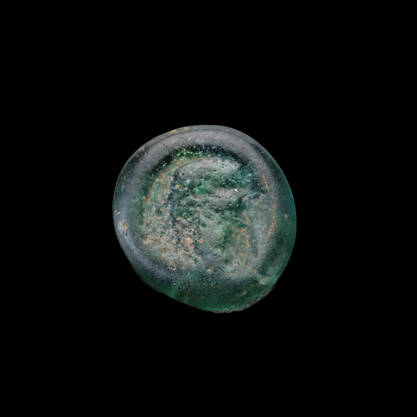 A ROMAN GLASS SEAL, 6TH-7TH CENTURY: A Roman glass seal, transparent light-green in colour, citing a female head and a man head on each side. 18 mm.