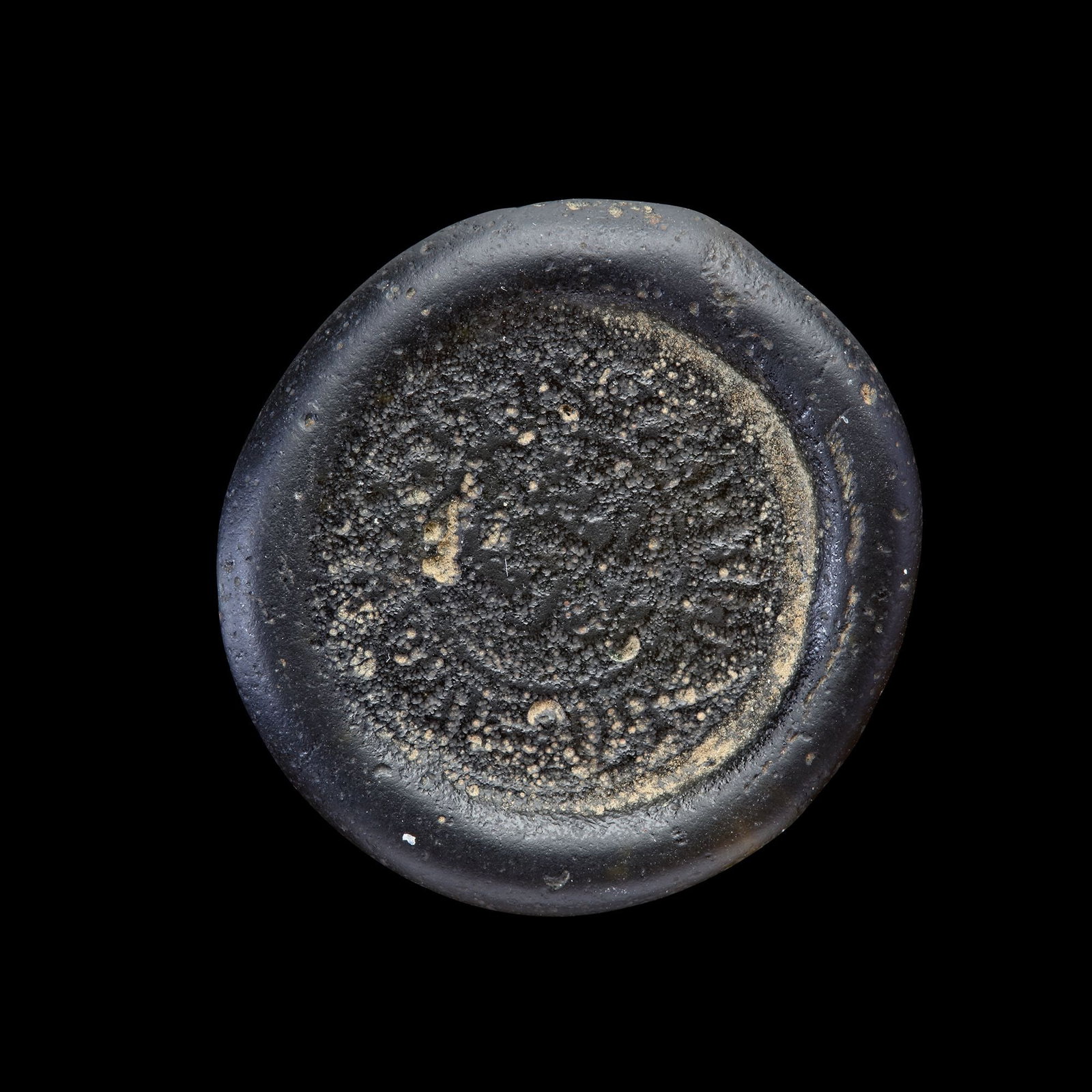 AN EARLY ISLAMIC GLASS WEIGHT OF DOUBLE DIRHAM: Glass weight, moulded and stamped, transparent dark-green in colour, citing in the centre with the name Al-Imam Abu Tamim al-Mustansir Amir al-Mu'mnin (427-487 AH/1036-1094 AD). 5.115 g., 27.7 mm. coi