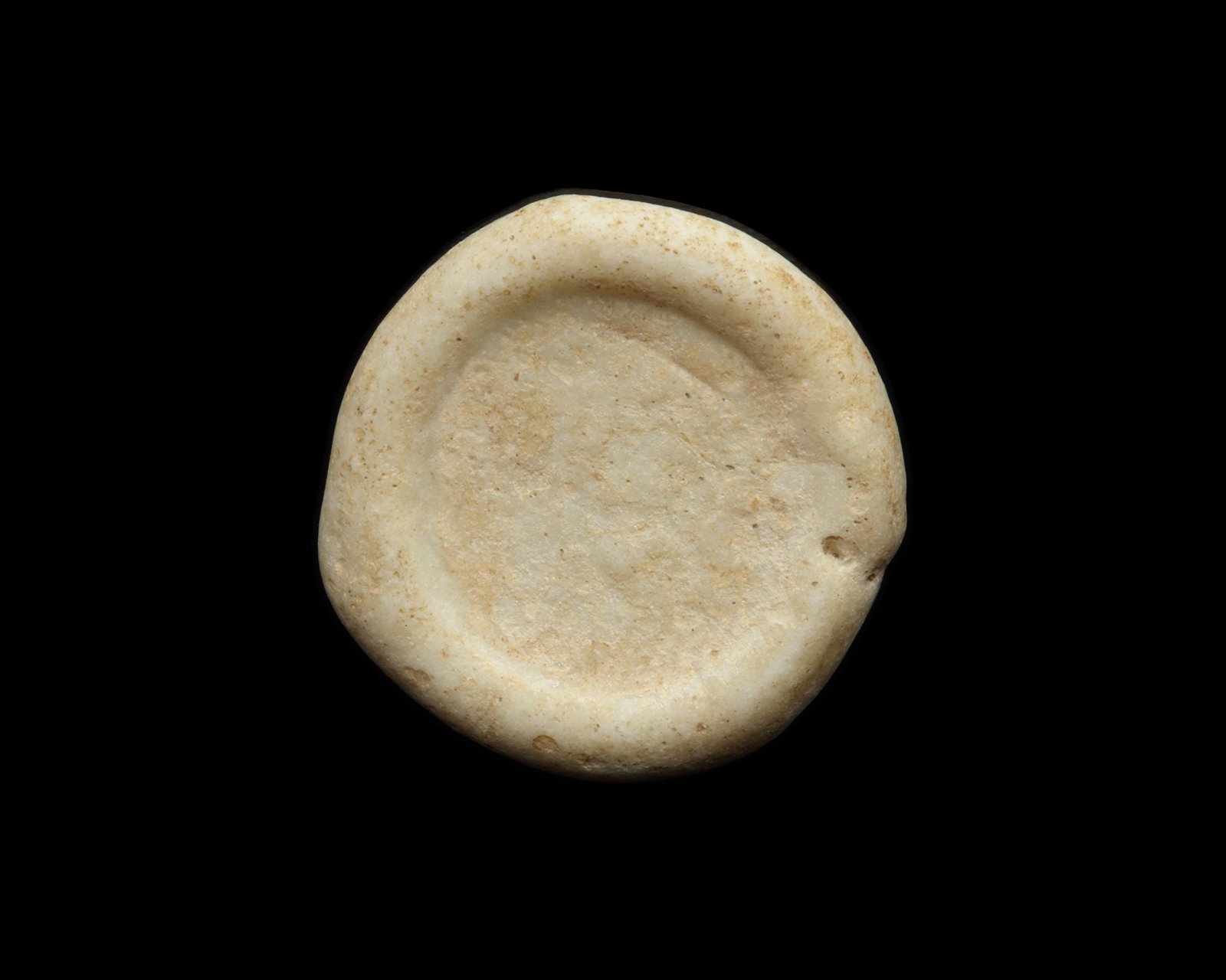 AN EARLY ISLAMIC GLASS WEIGHT OF DOUBLE DIRHAM: Glass weight, moulded and stamped, opaque white in colour, citing in the centre with the name Al-Aziz Billah (364-386 AH/975-996 AD). 5.875 g., 22 mm. coin weight: double dirham.