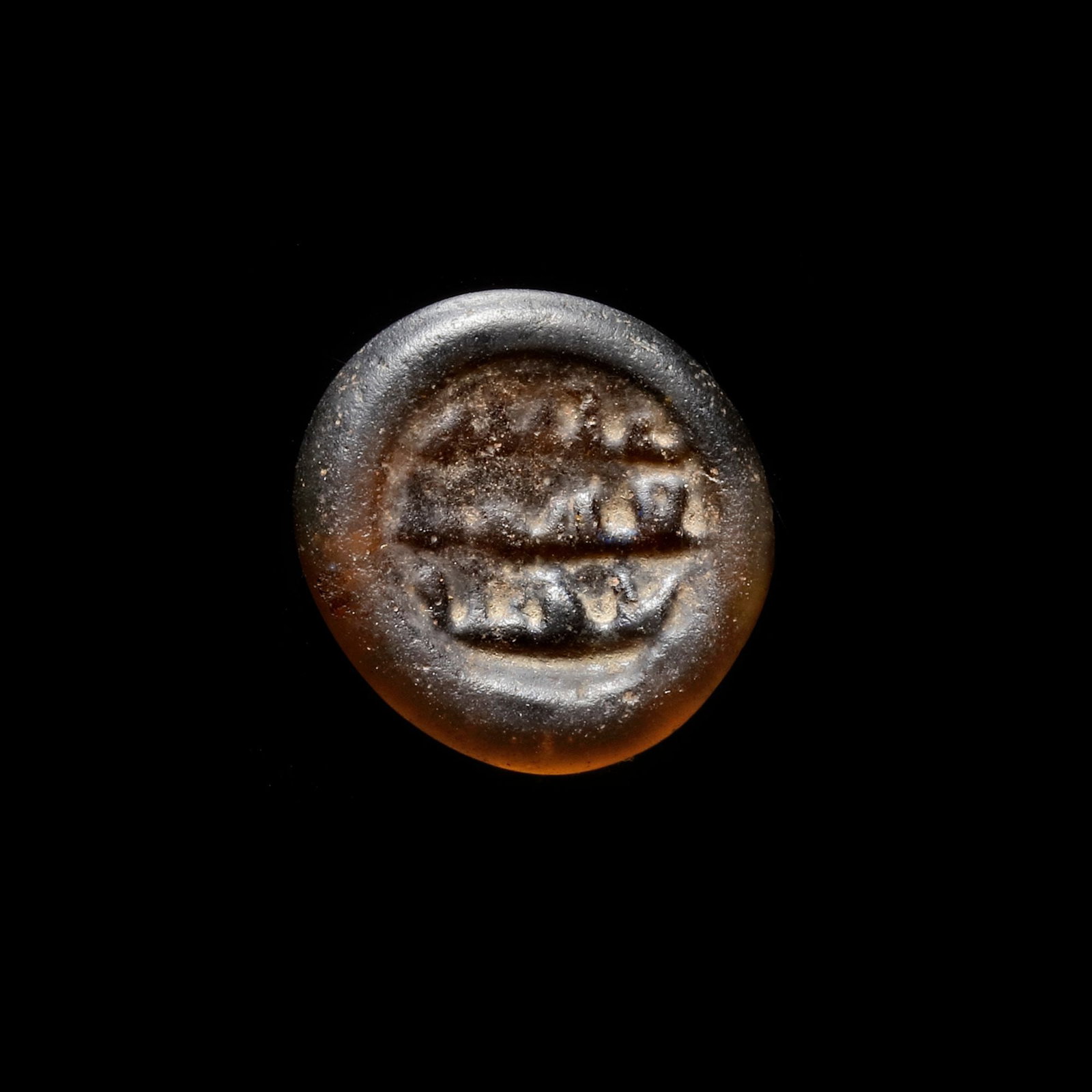 AN EARLY ISLAMIC GLASS WEIGHT OF DIRHAM, 10TH-11TH CENTURY: Glass weight, moulded and stamped, transparent brown in colour, citing in the centre with 3 lines of undeciphered Arabic text. 3,042 g., 21,4 mm. coin weight: dirham.