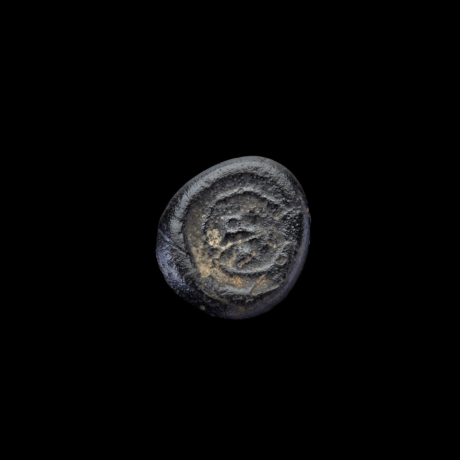 AN EARLY ISLAMIC GLASS WEIGHT OF QUARTER DINAR: Glass weight, moulded and stamped, dark-violet in colour, citing in the centre with the name Ma'ad (427-487AH/1036-1094 AD). 1.155 g., 13 mm. coin weight: quarter dinar. B 258