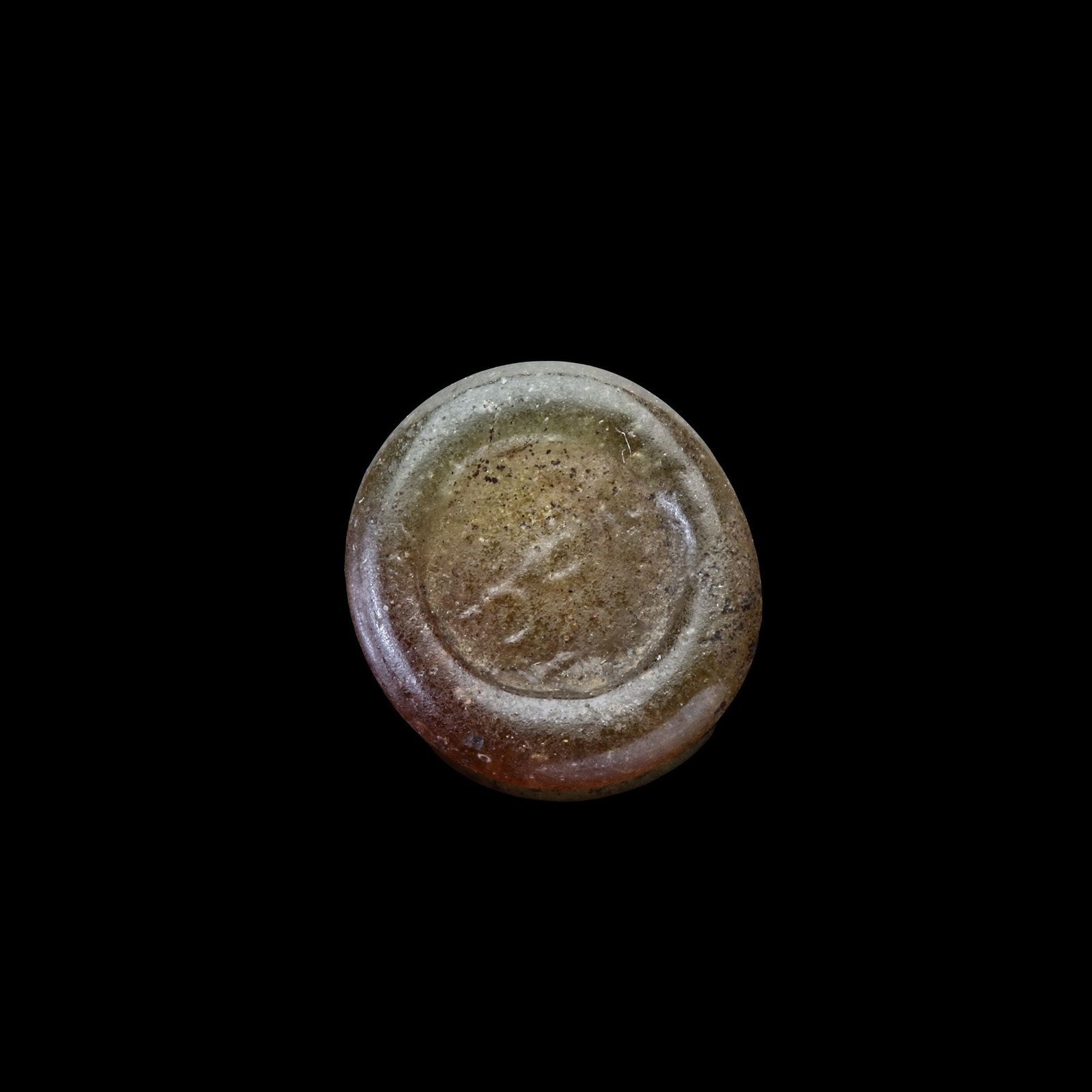 AN EARLY ISLAMIC GLASS WEIGHT OF QUARTER DINAR, 11TH-12TH CENTURY: Glass weight, moulded and stamped, transparent pale-brown in colour, citing in the centre with the name "Adl or justice". 0.902 g., 12 mm. coin weight: quarter dirham. LP1891