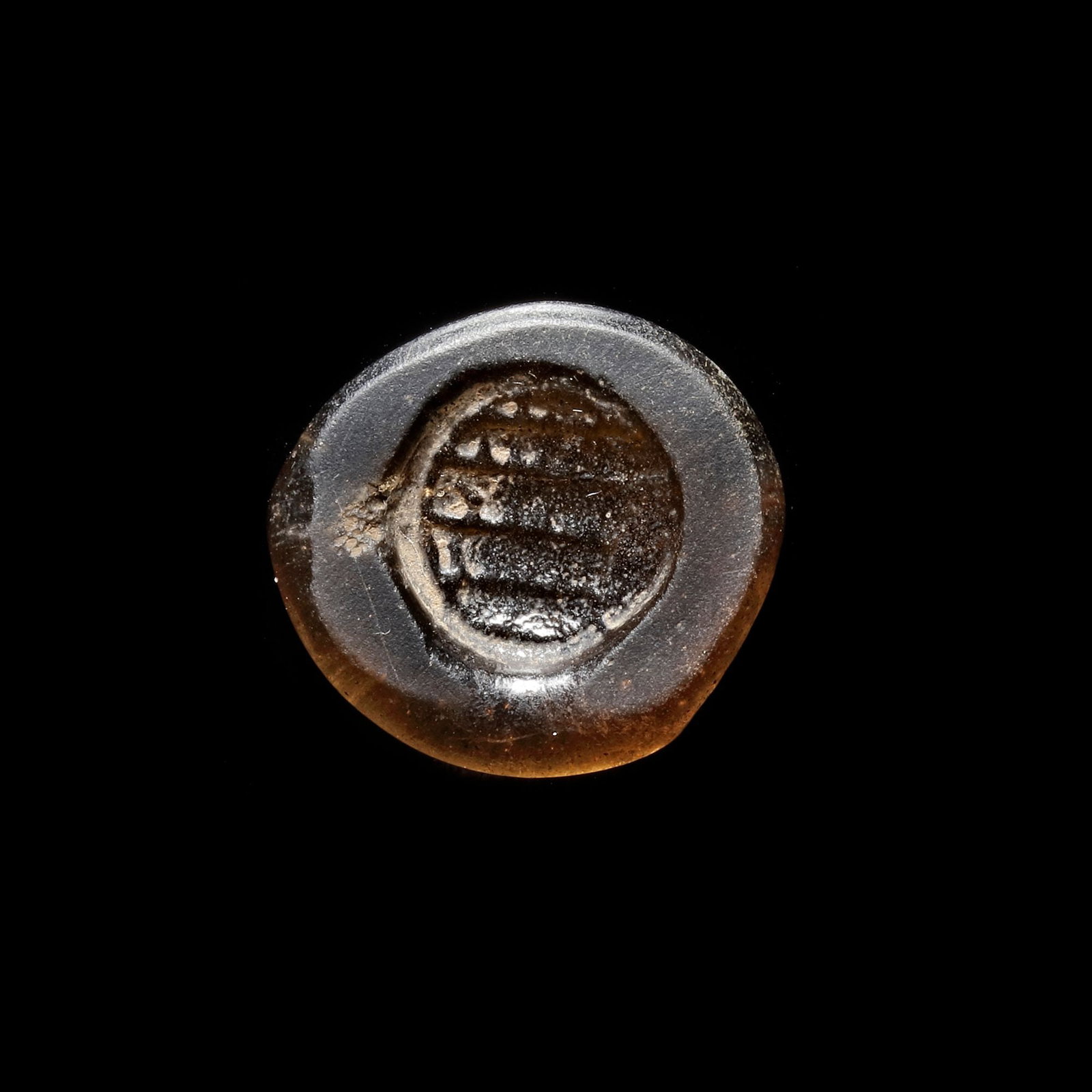 AN EARLY ISLAMIC GLASS WEIGHT OF DOUBLE DIRHAM, 10TH-11TH CENTURY: Glass weight, moulded and stamped, transparent brown in colour, citing in the centre with 4 lines of undeciphered Arabic text. 5.891 g., 26 mm. coin weight: double dirham.