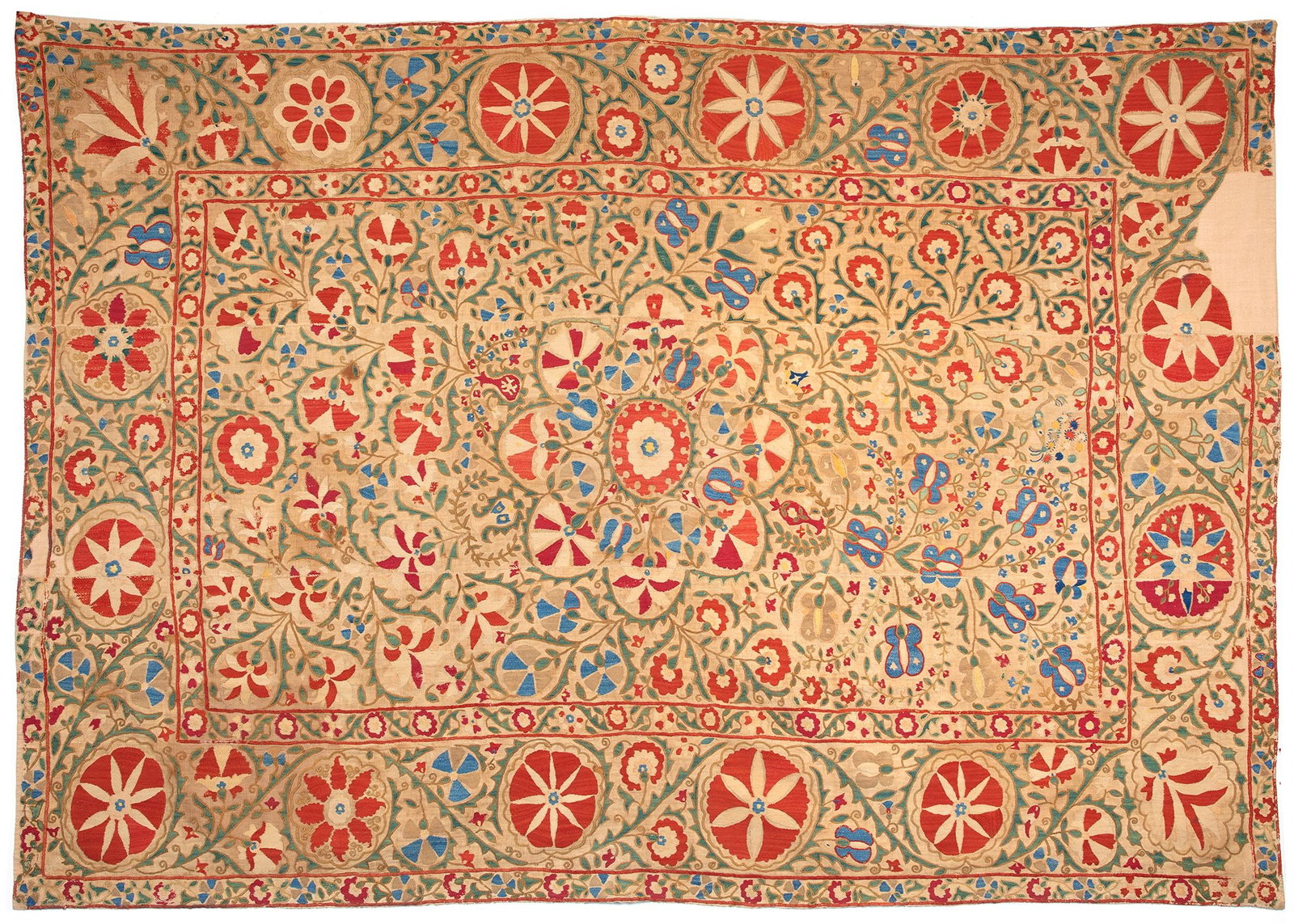 A SUZANI, BUKHARA, UZBEKISTAN, FIRST HALF 19TH CENTURY: A magnificent Bokhara suzani presenting a very dense field design. The Flower -shaped medallion in the central axis barely stand out from the wealth of flowering shrubs pointing in different direction