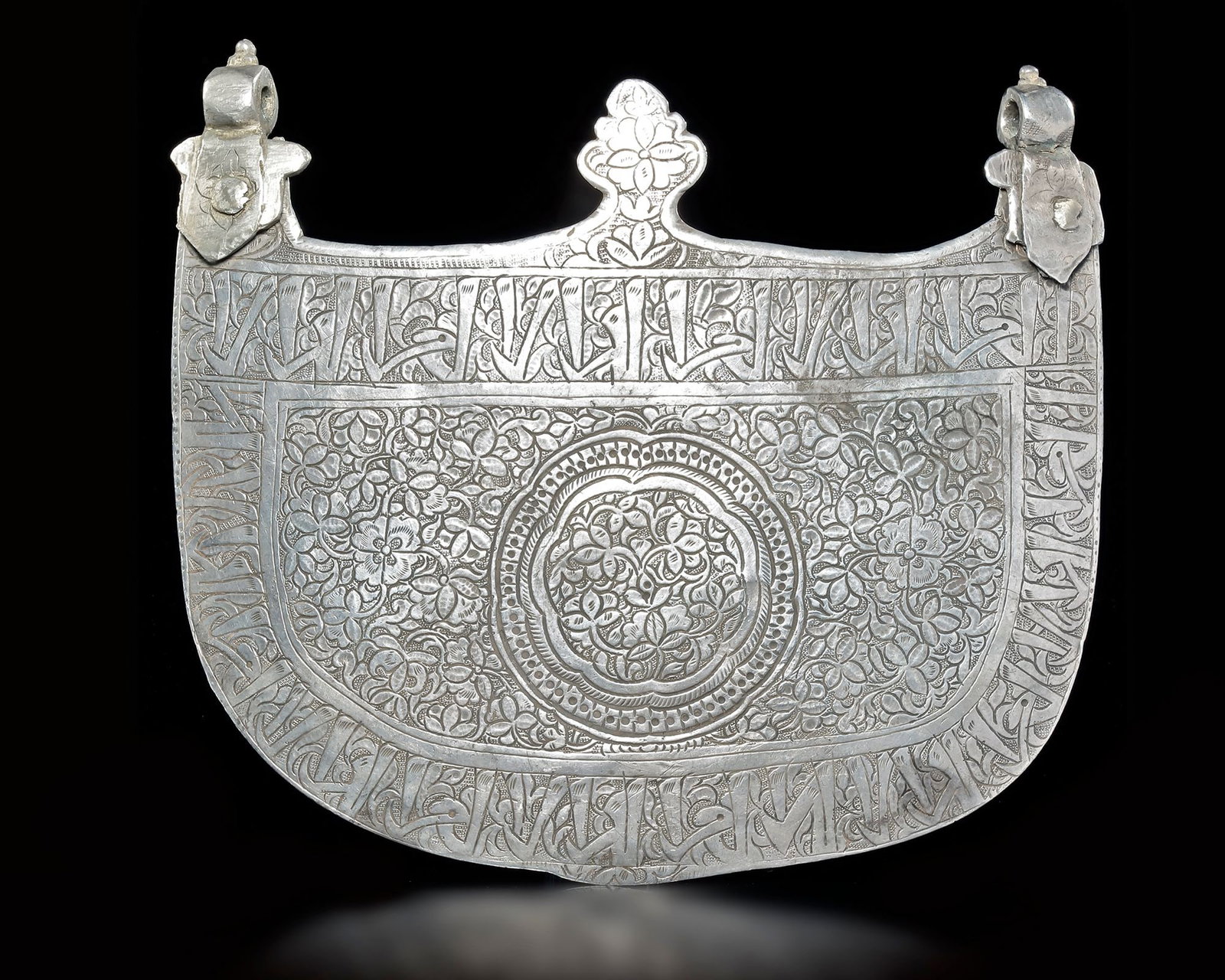 A TIMURID SILVER PECTORA, PERSIA, LATE 15TH CENTURY: Curved form with horn-like finials, each with a lobed a finely engraved Timurid silver pectoral of curved form, terminating in horn-like finials with suspension loops. the surface is richly decorated 