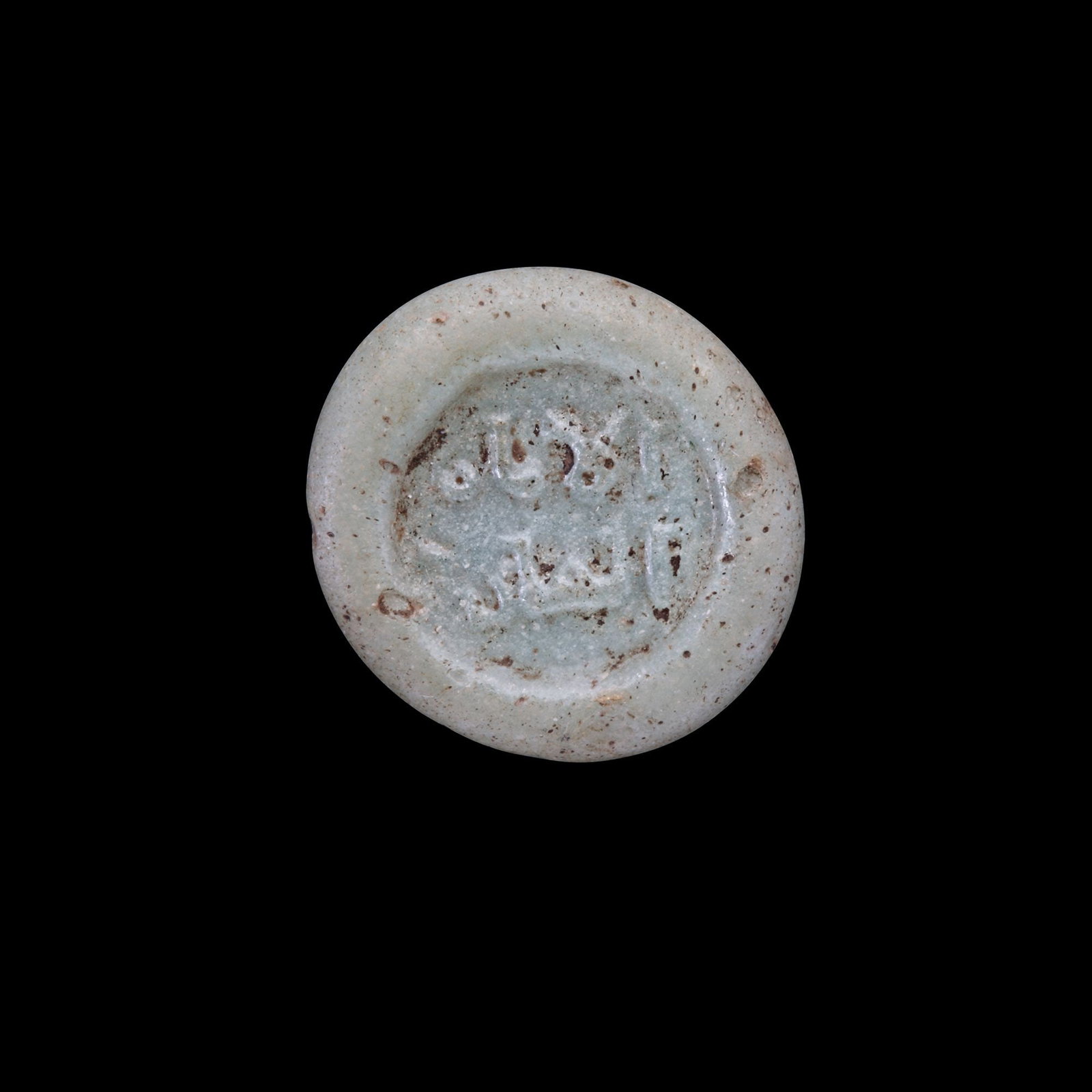 AN EARLY ISLAMIC GLASS WEIGHT OF HALF DIRHAM (1 of 2)