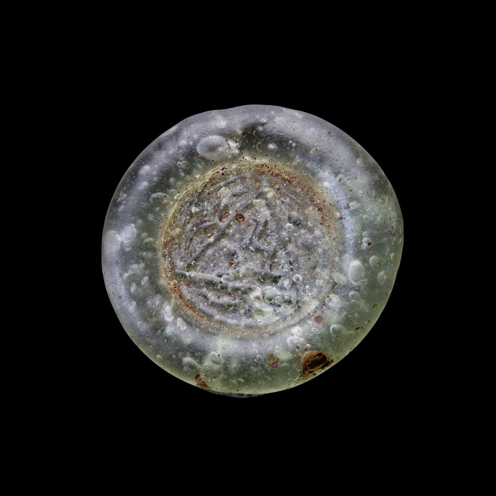 AN EARLY ISLAMIC GLASS WEIGHT OF DOUBLE DIRHAM, 10TH-11TH CENTURY: Glass weight, moulded and stamped, transparent light-green in colour, citing in the centre with the word " Muhammed within a triangle". 5.980g, 26 mm. coin weight: double dirham.