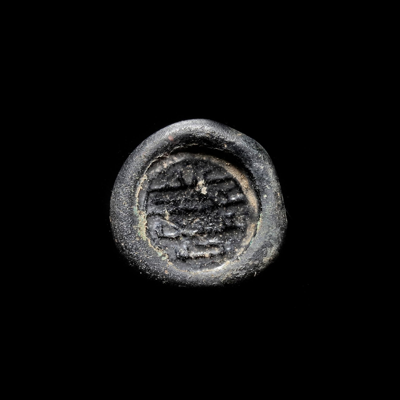 AN EARLY ISLAMIC GLASS WEIGHT OF DIRHAM, 10TH-11TH CENTURY: Glass weight, moulded and stamped, dark violet in colour, citing in the centre with 4 lines of undeciphered Arabic text. 2,904 g., 20 mm. Coin weight: dirham.