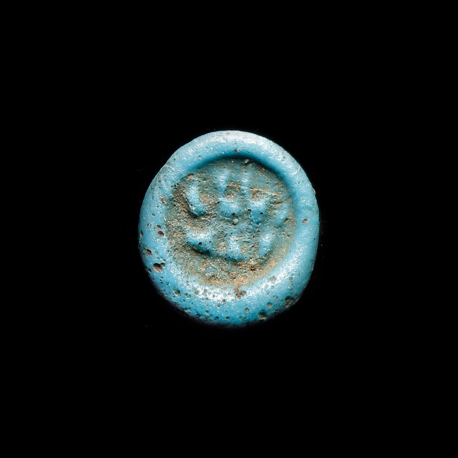 AN EARLY ISLAMIC GLASS WEIGHT OF QUARTER DINAR: Glass weight, moulded and stamped, turquoise-blue in colour, citing in the centre with the name Amir Ma'ad (427-487 AH/1036-1094 AD). 1.257 g., 23 mm. coin weight: quarter dinar. B 273, N 87-99
