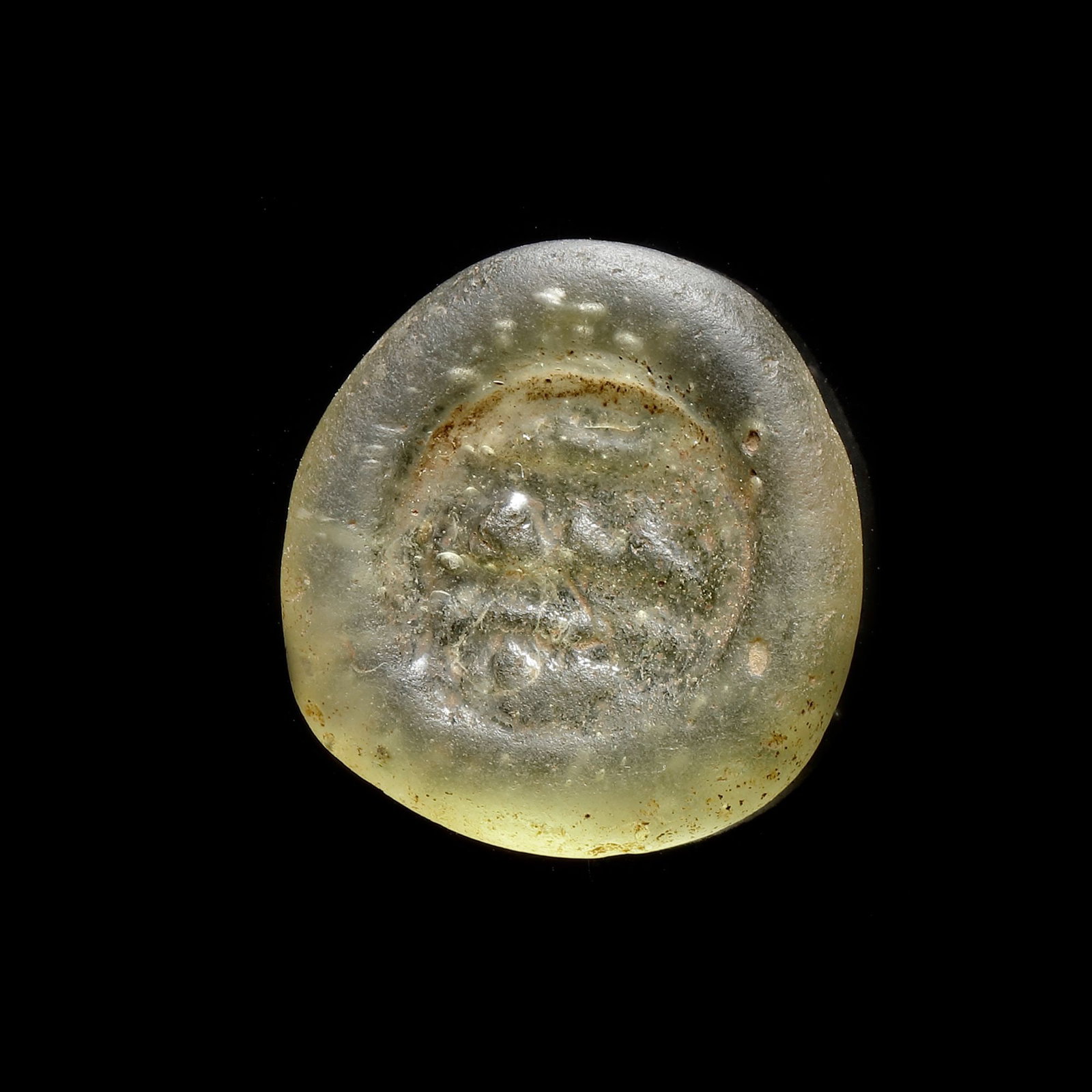 AN EARLY ISLAMIC GLASS WEIGHT OF DOUBLE DIRHAM, 10TH-11TH CENTURY: Glass weight, moulded and stamped, transparent light-green in colour, citing in the centre with 3 lines of undeciphered Arabic text. 6.115 g., 24 mm. coin weight: double dirham.