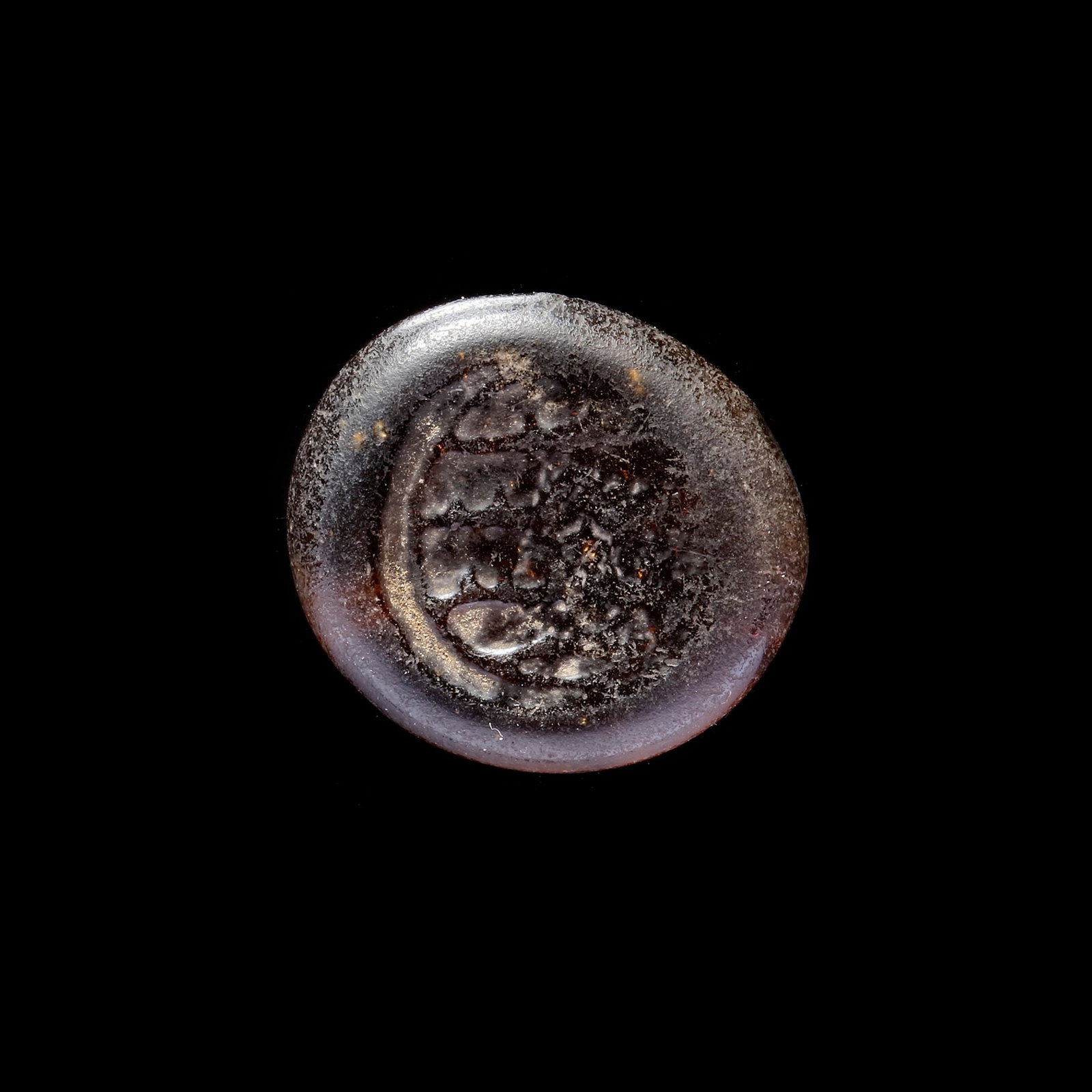 AN EARLY ISLAMIC GLASS WEIGHT OF DIRHAM, 10TH-11TH CENTURY: Glass weight, moulded and stamped, transparent brown in colour, citing in the centre with 4 lines of undeciphered Arabic text. 3.046g, 20.9 mm. coin weight: dirham.