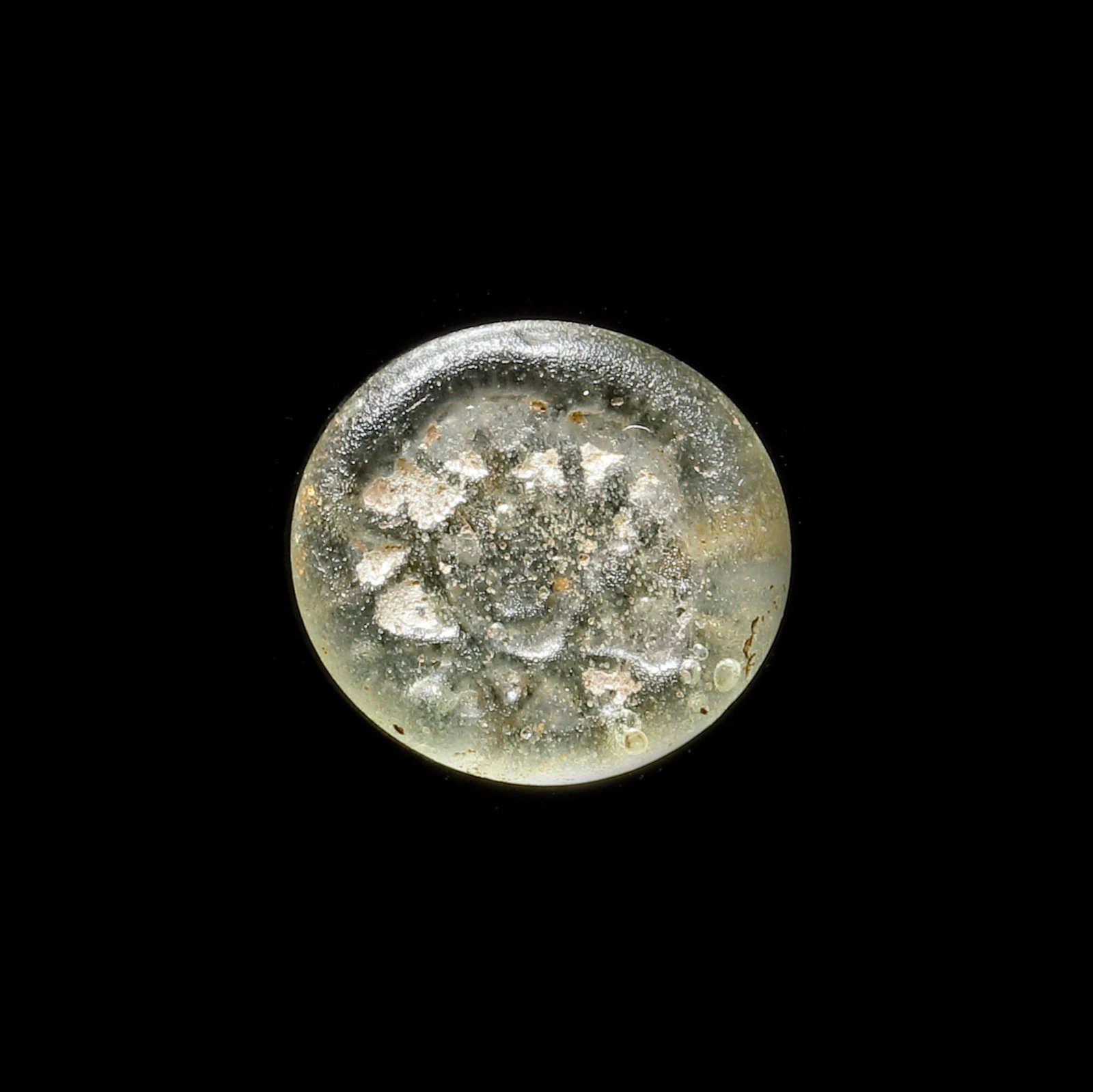 AN EARLY ISLAMIC GLASS WEIGHT OF HALF DIRHAM, 10TH-11TH CENTURY: Glass weight, moulded and stamped, transparent pale-green in colour, citing in the centre with the star of Solomon. 1.366g, 15 mm. coin weight: half dirham.