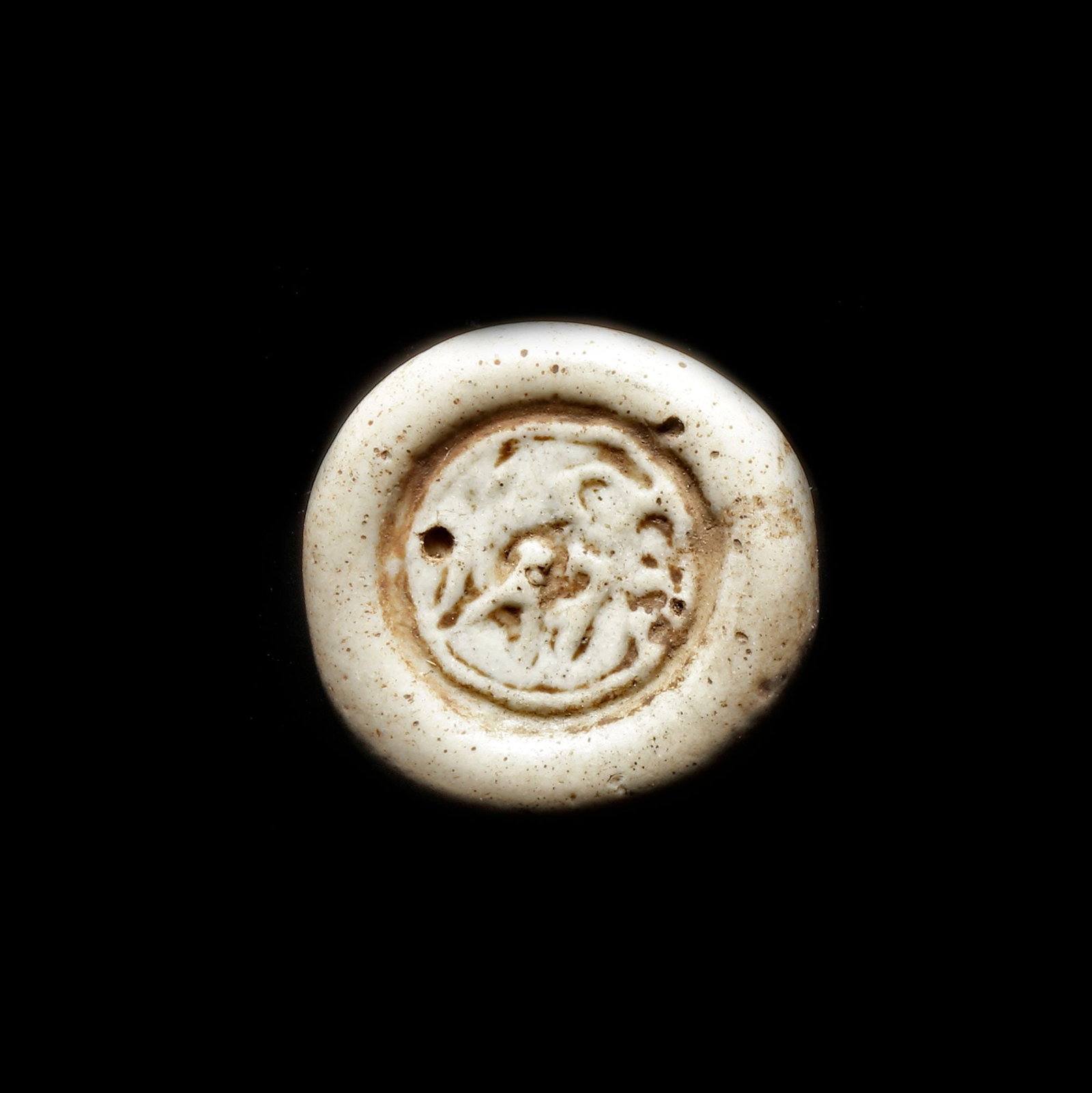AN EARLY ISLAMIC GLASS WEIGHT OF DOUBLE DIRHAM, 10TH-11TH CENTURY: Glass weight, moulded and stamped, opaque white in colour, citing in the centre with 3 lines of undeciphered Arabic text. 6.085 g., 23 mm. coin weight: double dirham.