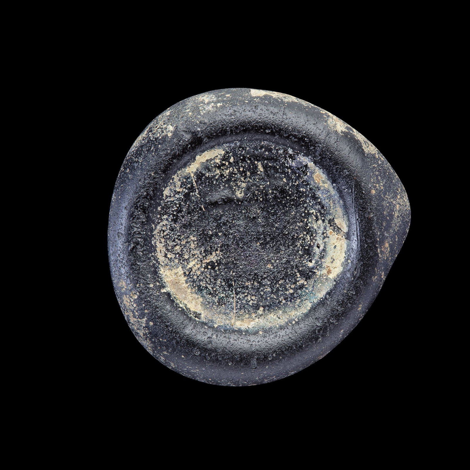 AN EARLY ISLAMIC GLASS WEIGHT OF DIRHAM: Glass weight, moulded and stamped, opaque dark-black in colour, citing in the centre with the name Ma'ad Amir al-Mu'mnin ( 427-487 AH/1036-1094 AD). 5.970 g., 26.2 mm. coin weight: Double dirham.