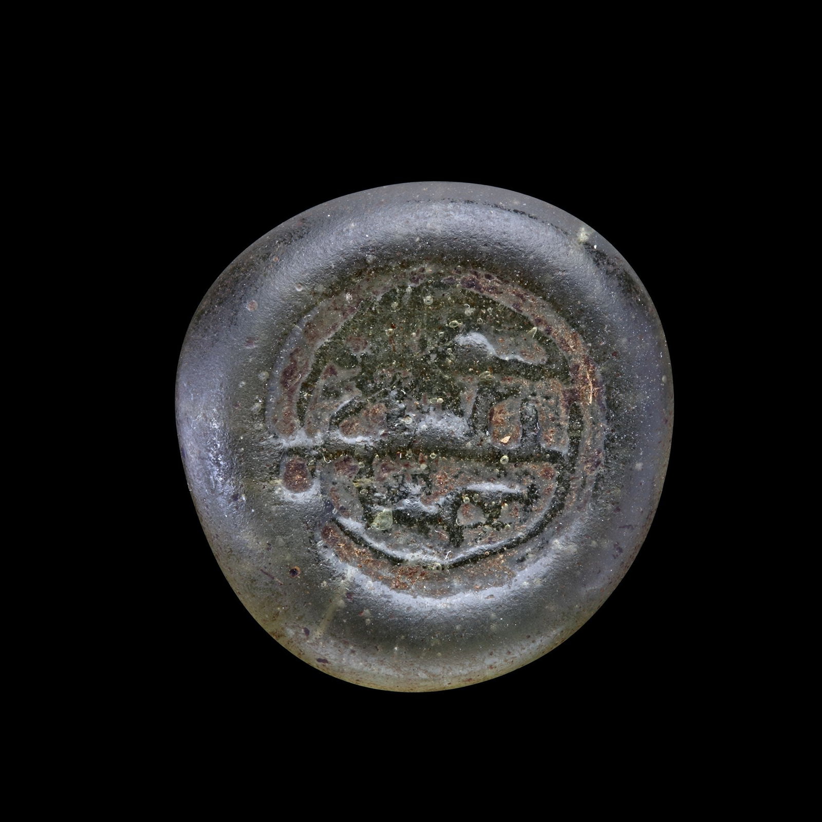 AN EARLY ISLAMIC GLASS WEIGHT OF DOUBLE DIRHAM, 10TH-11TH CENTURY: Glass weight, moulded and stamped ,transparent pale-green in colour, citing in the centre with 3 lines of undeciphered Arabic text. 6.089 g., 25.4 mm. coin weight: double dirham.