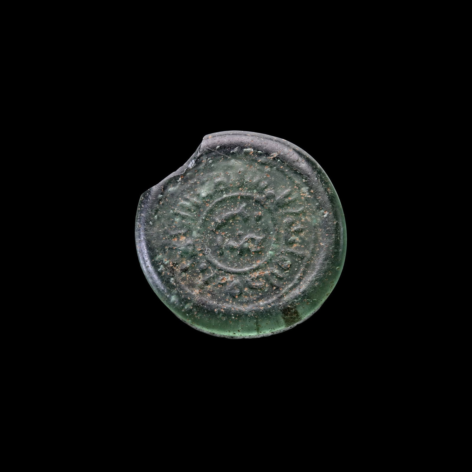 AN EARLY ISLAMIC GLASS WEIGHT OF DIRHAM: Glass weight, moulded and stamped, transparent pink-violet in colour, citing in the centre with the name Amir al-Mu'mnin, surrounded by Al-Imam Ma'ad Abu Tamim al-Mustansir (427-487 AH/1036-1094 AD). 