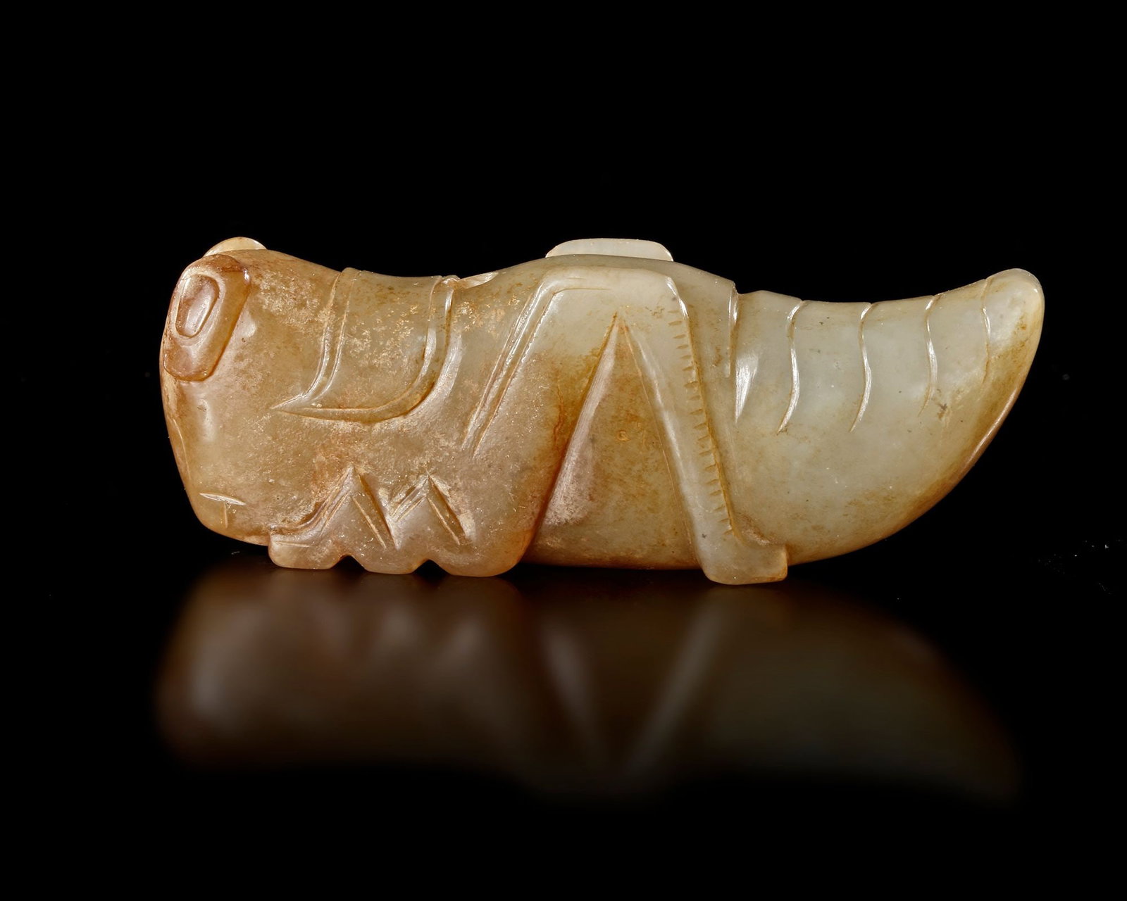 A CHINESE JADE GRASSHOPPER PENDANT, HAN DYNASTY (206 BCâ€“220 AD): A finely carved yellowish-green jade grasshopper pendant, symbolizing abundance, longevity, and prosperity in ancient Chinese culture. The elegant form is rendered with simple yet expressive details. 