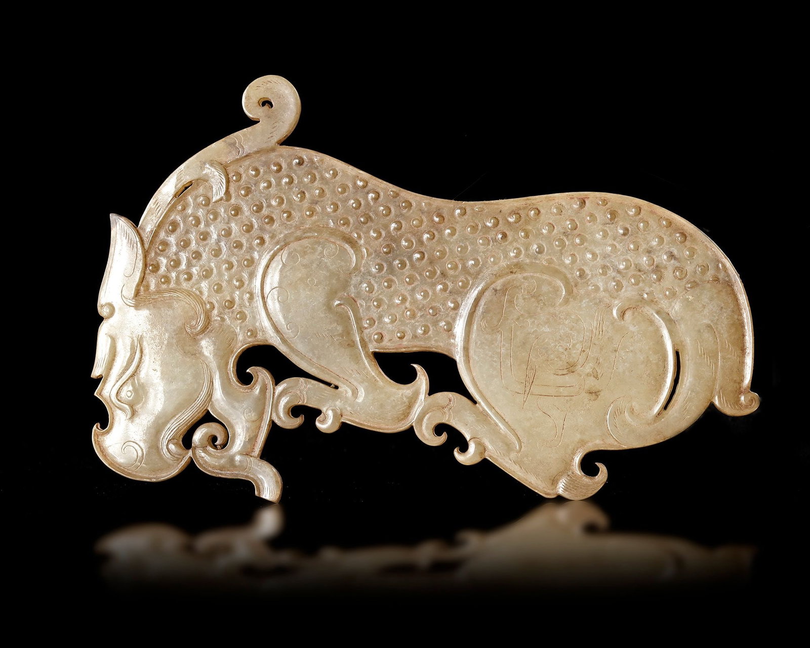 A YELLOW JADE TIGER PLAQUE, CHINA, ZHOU - EARLY HAN PERIOD (1046-150 BC): An elegant yellow jade plaque carved in the form of a stylized tiger, showcasing the refined artistry of ancient China. The openwork design, finely incised details, and graceful scrolling motifs refle