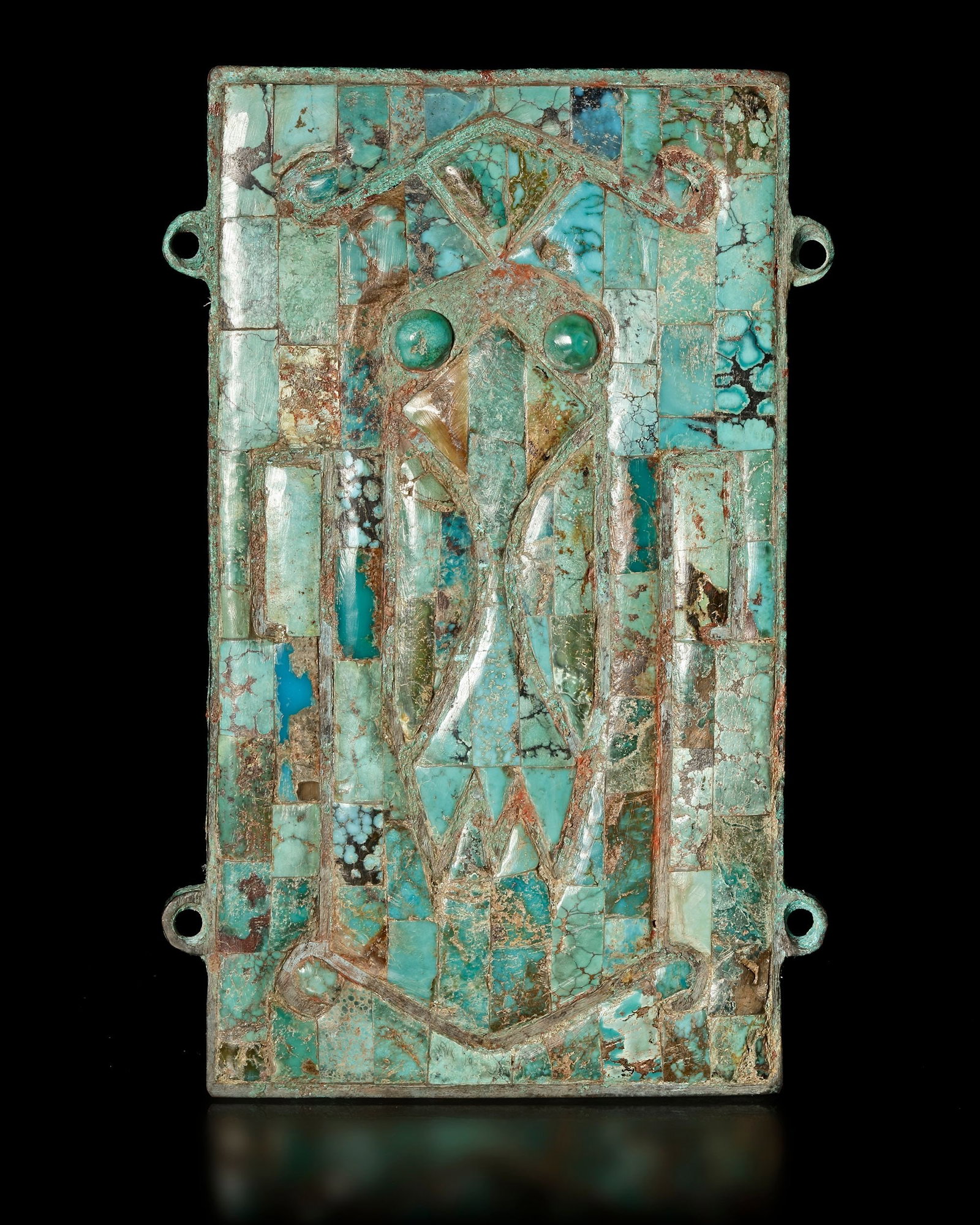 A TURQUOISE-INLAID PENDANT, SHANG DYNASTY (CIRCA 1600-1046 BC): Ancient pendant composed of turquoise inlays set into a metal plaque, forming a stylized mask motif characteristic of early Chinese ritual art. Such ornaments were often associated with ritual or cere