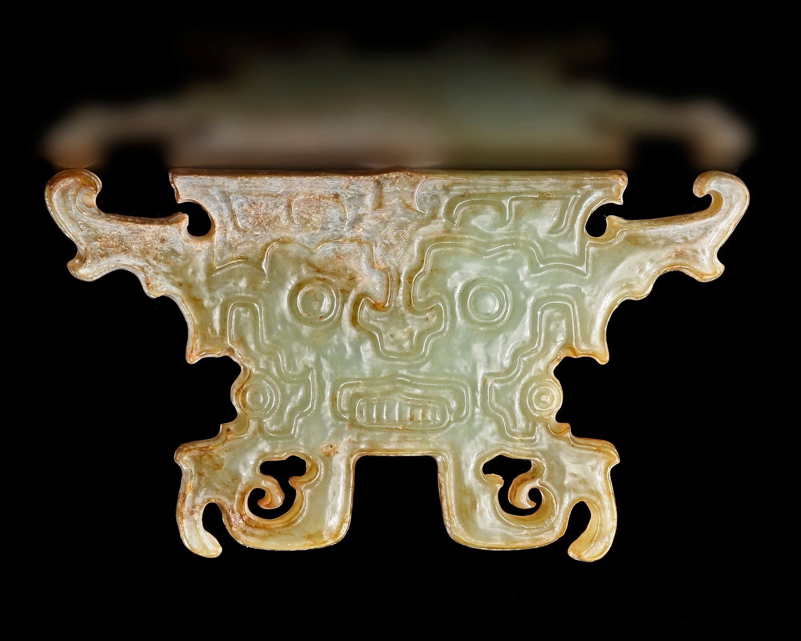 A GREEN JADE ANCESTOR MASK, POST-SHIJIAHE CULTURE (c 2000-1800 BC): An exceptional green jade ancestor mask from the post-Shijiahe cultural tradition of the Neolithic period. Finely carved with a stylized human face featuring prominent circular eyes, geometric contour