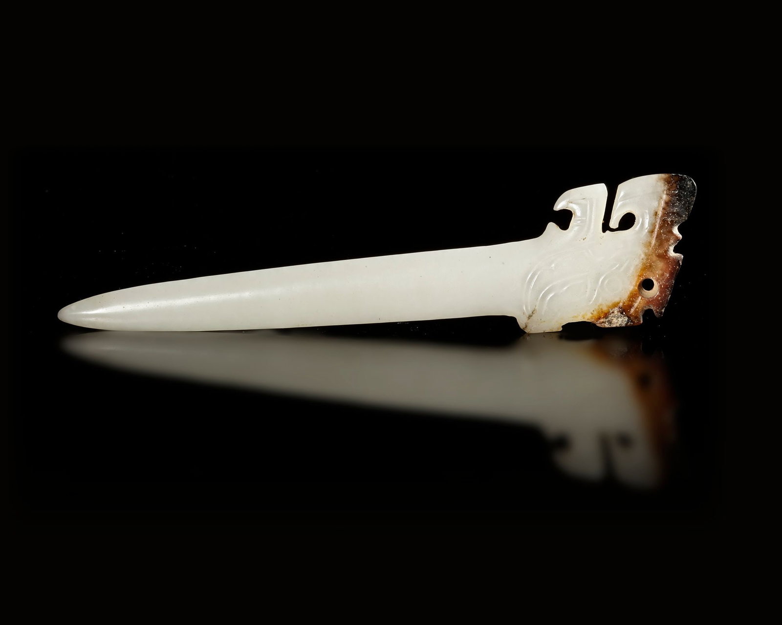 A WHITE JADE HAIRPIN, CHINA, SHANG DYNASTY. (c. 1600â€“1046 BC).: A finely carved white jade hairpin . The slender shaft tapers elegantly to a smooth point, while the upper section is decorated with stylized motifs, Length: 11.5 cm Provenance: Private collection mr.