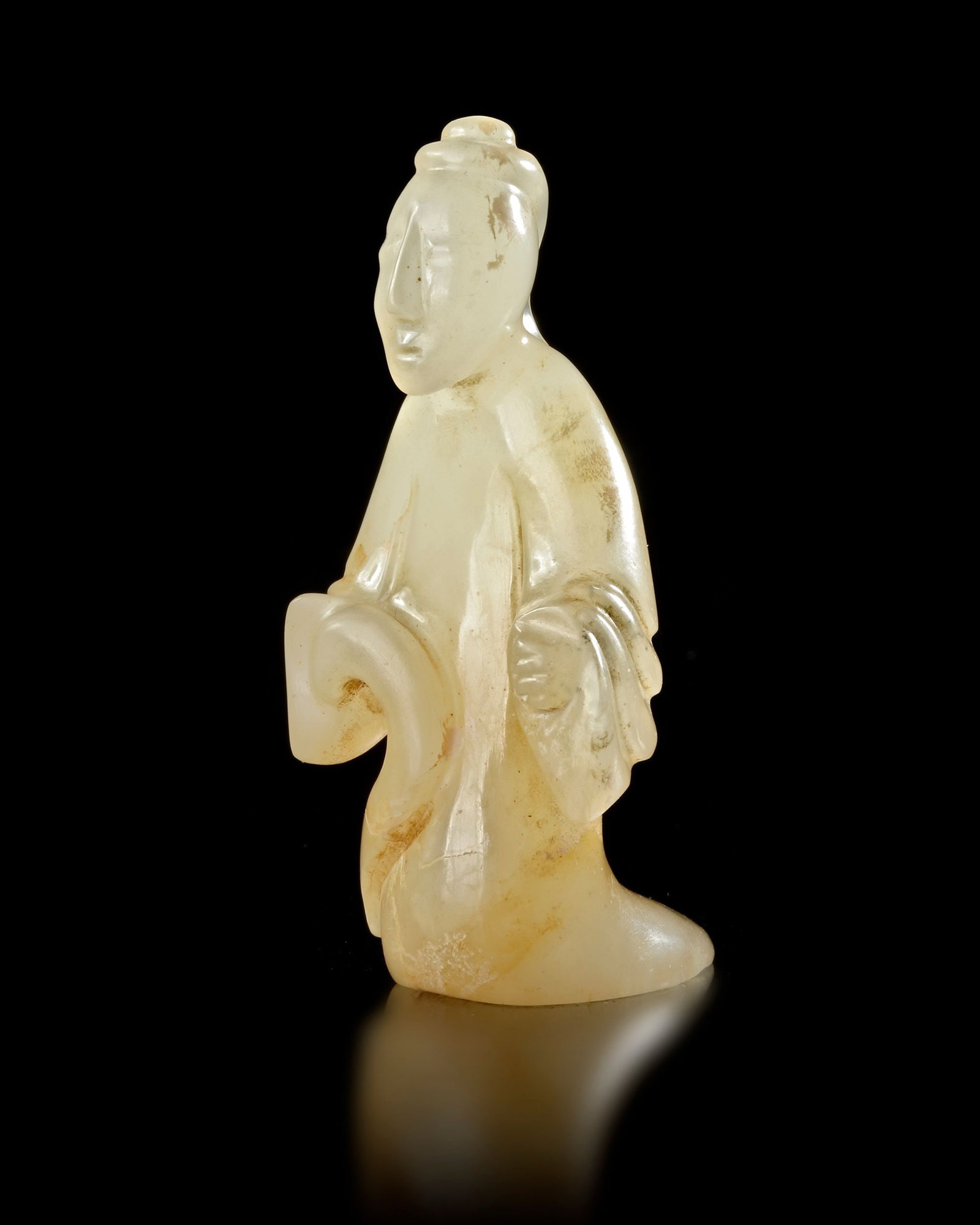 A JADE LADY FIGURE, CHINA, HAN DYNASTY (206 BC â€“ 220 AD): Elegantly carved jade figure of a standing woman from the Han Dynasty. The figure is depicted in flowing robes, holding an object in her hands, with a serene facial expression and stylized hair. The s