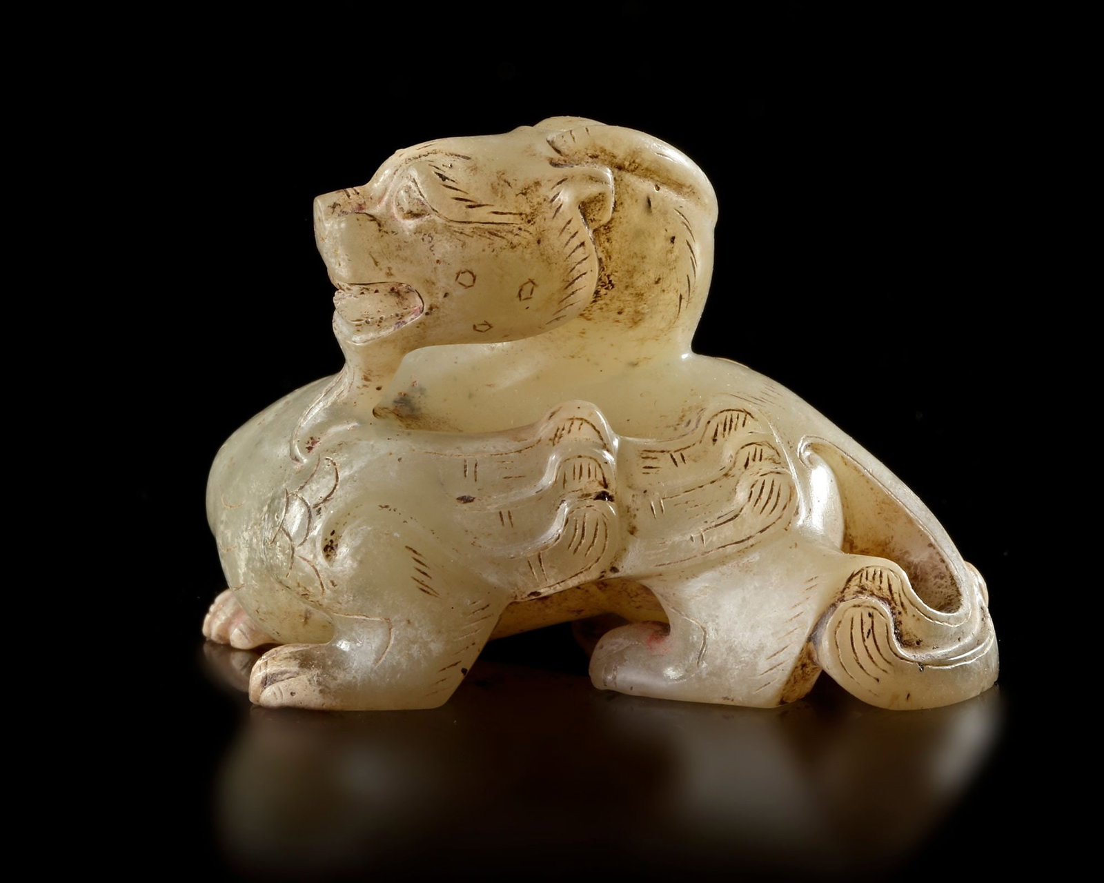 A JADE ANIMAL FIGURE, CHINA, ZHOU DYNASTY (c. 1046â€“256 BC): Small carved jade figure depicting a mythical animal with stylized wings and expressive features , 5 by 4 by 3 cm. Provenance: Private collection mr. J.K., Switzerland