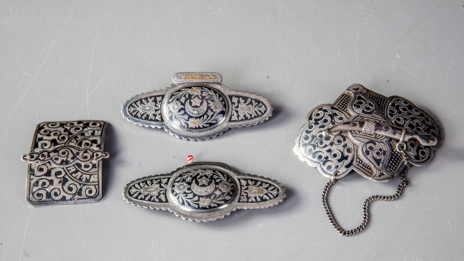 FOUR SILVER BUCKLES, IRAQ, EARLY 20TH CENTURY: Total weight: 136 cm. Between 9 by 4 and 9 by 6 cm.