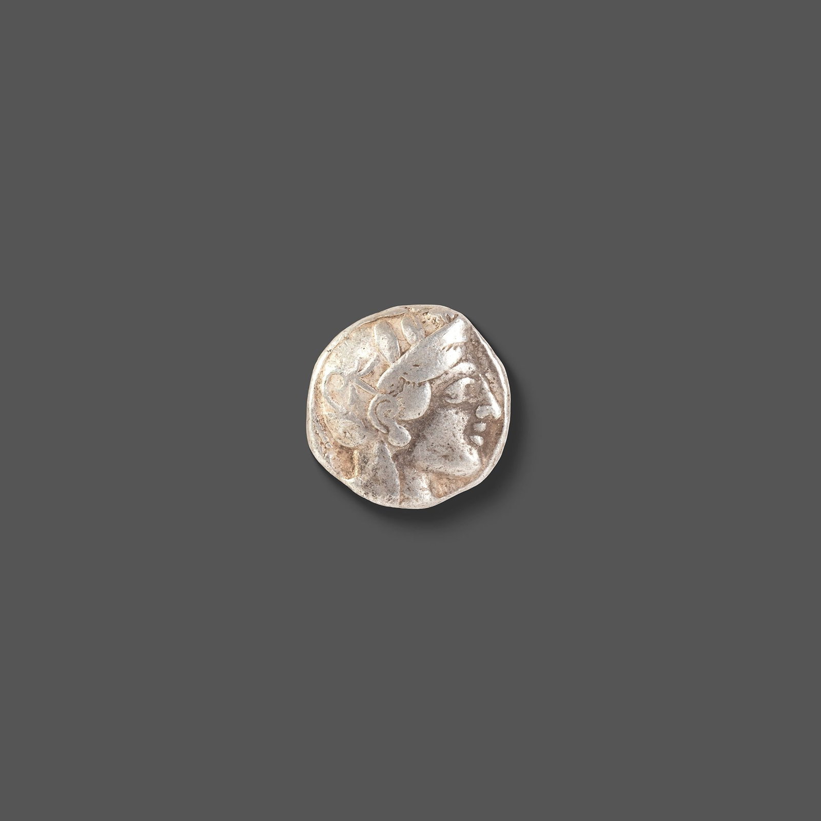 ATHENIAN SILVER TETRADRACHM ATTICA, ATHENS, CIRCA 465â€“454 BC: A classic ancient Athenian silver tetradrachm featuring the helmeted head of Athena on the obverse and the iconic owl of Athens on the reverse, accompanied by an olive sprig and crescent. Struck durin