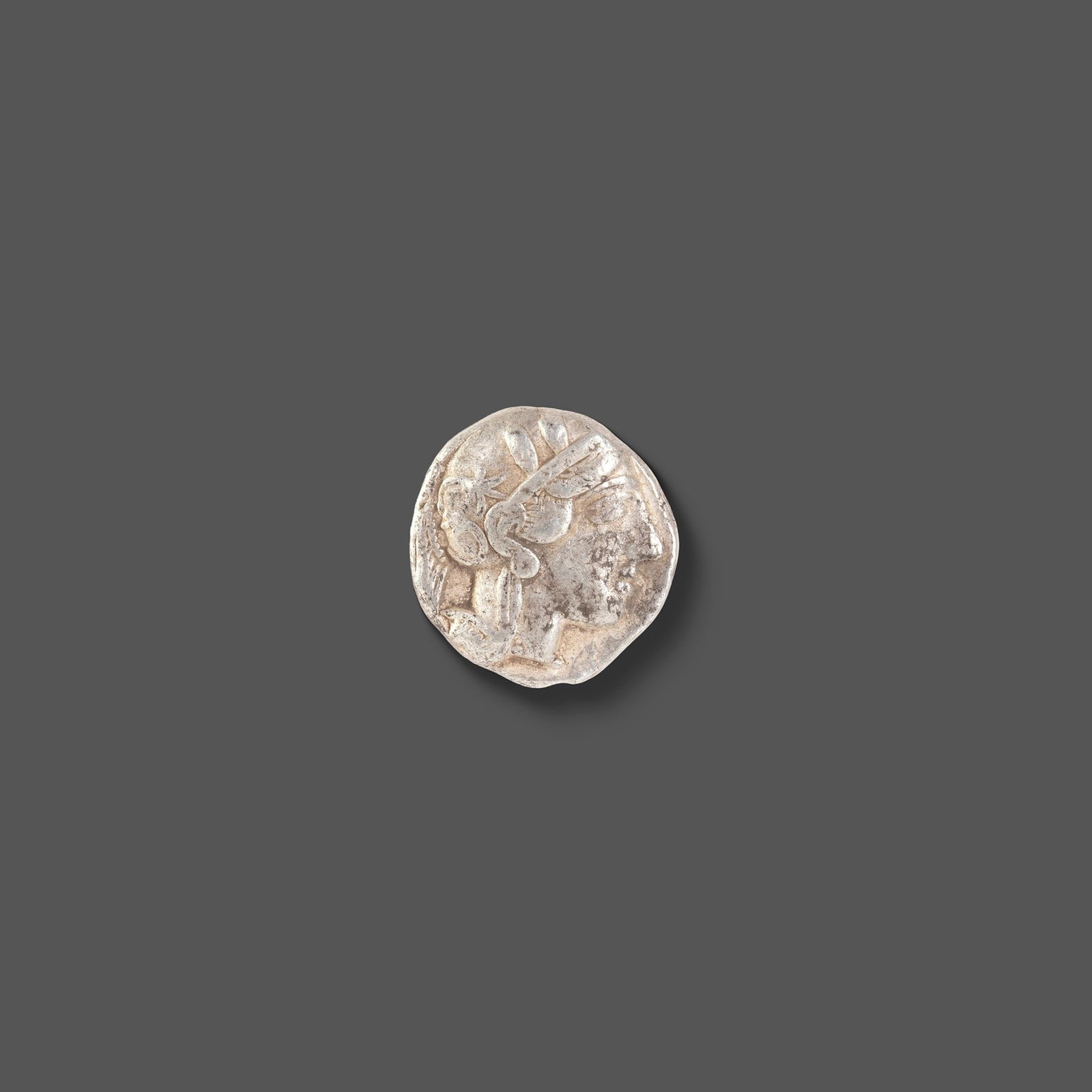 ATHENIAN SILVER TETRADRACHM ATTICA, ATHENS, CIRCA 465â€“454 BC: A classic ancient Athenian silver tetradrachm featuring the helmeted head of Athena on the obverse and the iconic owl of Athens on the reverse, accompanied by an olive sprig and crescent. Struck durin