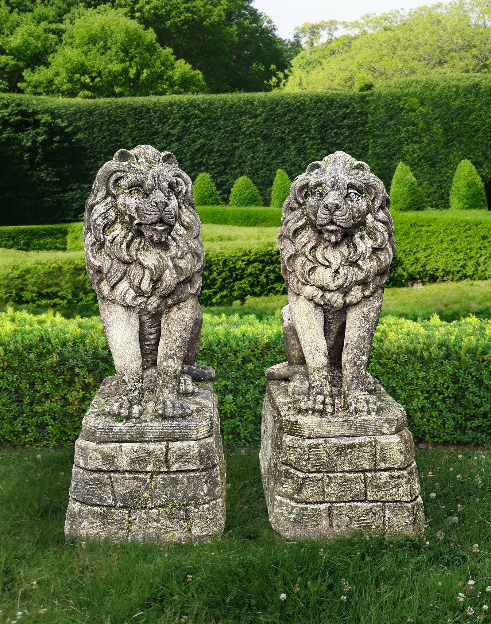 A PAIR OF SCULPTED LIMSTONE MODELS OF LIONS ON PEDESTALS: Each modeled sitting and staring forward, on a rock work plinth. Height overall 90 cm. Base 35 by 50 cm.