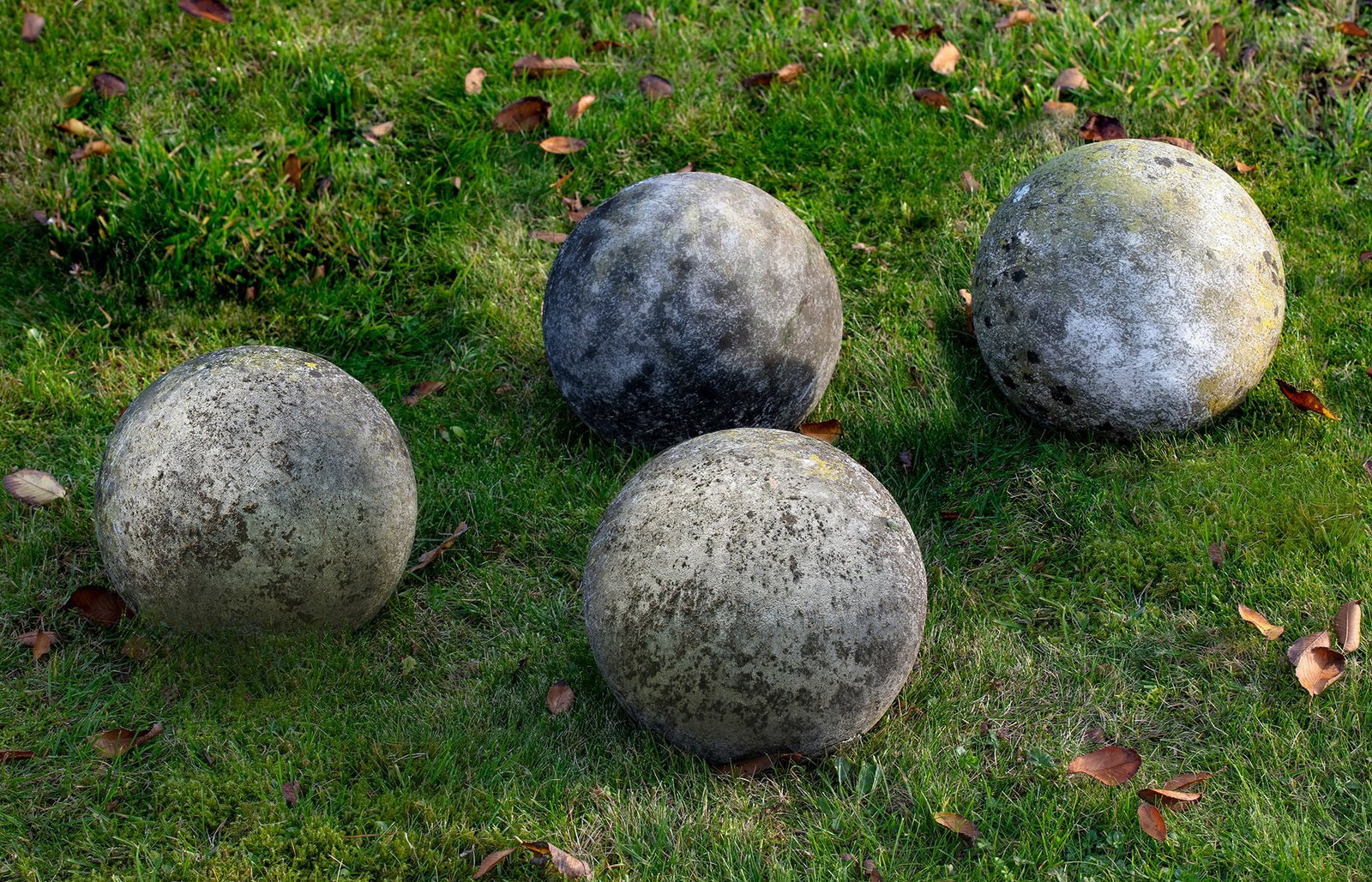 A GROUP OF FOUR LIMESTONE ORNAMENTAL SPHERES, LATE 20TH CENTURY: Probably lawn markers. Each ball approximately 50 cm. diameter.