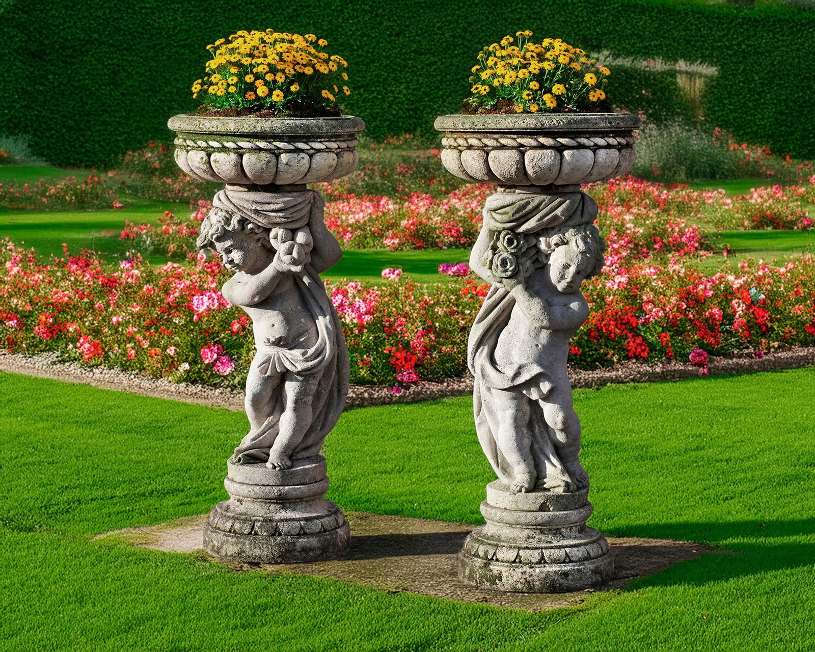 A PAIR OF SCULPTED LIMESTONE PEDESTAL PLANTERS, LATE 19TH CENTURY: Each modelled as an opposing putto holding the planter basin aloft above a spread base. Height 135 cm. The basins: diameter 60 cm. diameter at the base 45 cm.
